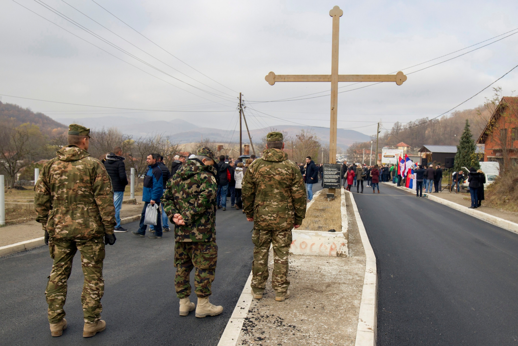 Slovenian troops serving in the NATO-led peacekeeping mission in Kosovo, observe Kosovo Serbs as they block a road in the village Rudare, north of Serb-dominated part of ethnically divided town of Mitrovica, Kosovo, Friday, Nov.23, 2018. Kosovo police arrested three ethnic Serbs, including two police officers, early Friday on suspicion of involvement in the killing of a leading Serb politician in the north of the country. (AP Photo/Bojan Slavkovic) Kosovo Serbs