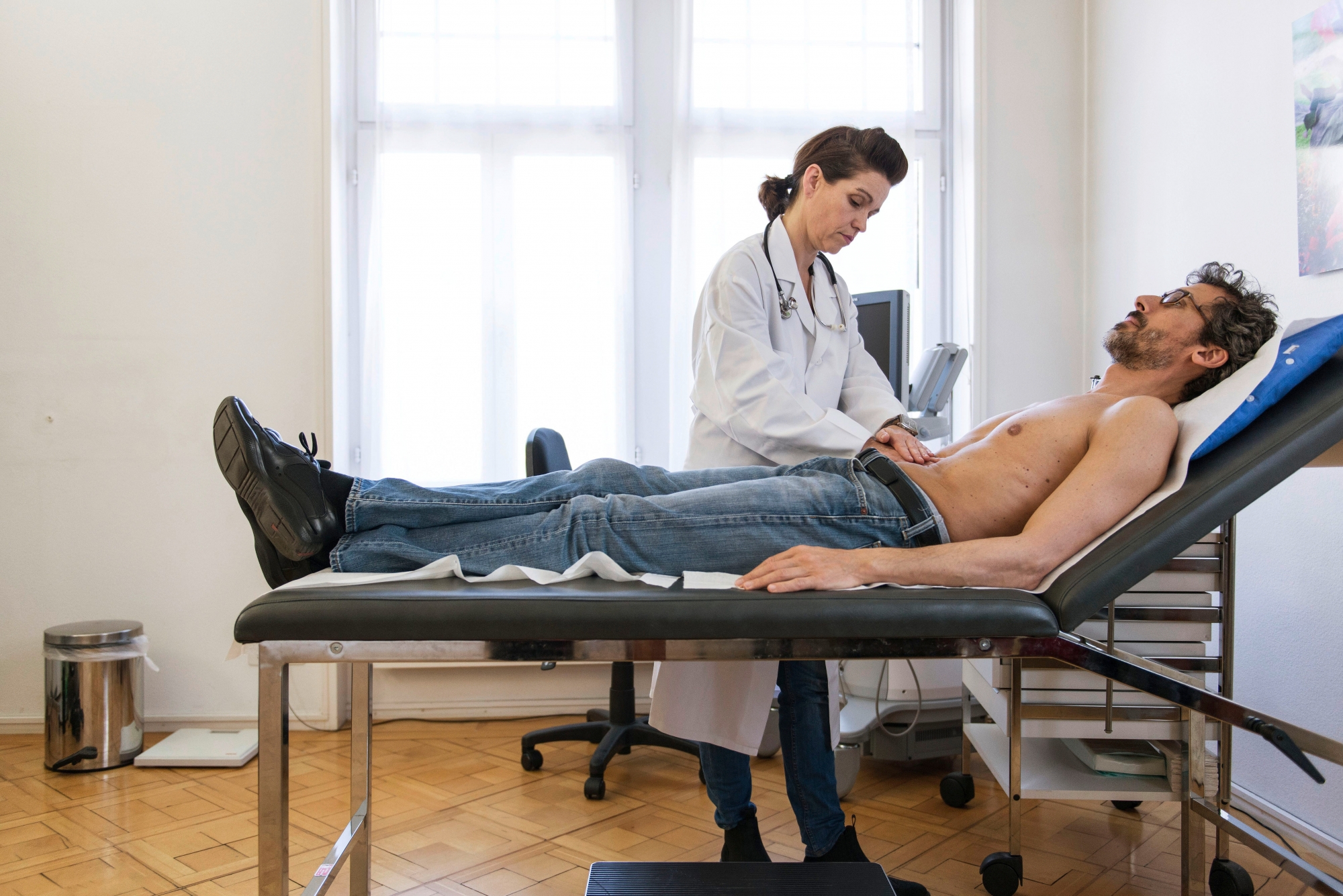 [EDITORS NOTE: POSED PICTURE] A doctor makes an abdomen examination on a patient, pictured on March 28, 2014. (KEYSTONE/Christian Beutler) SCHWEIZ HAUSARZT
