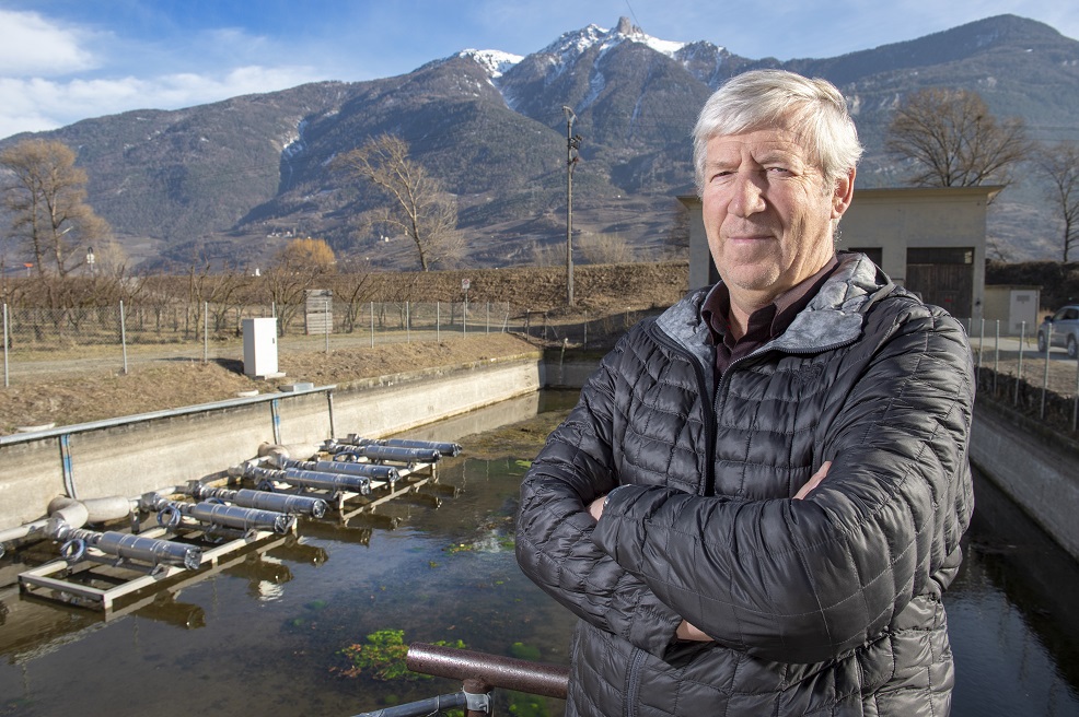 Président du consortium du Grand Blettay, Paul-Marie Dorsaz pose devant le bassin de rétention désormais muni de pompes pour alimenter le réseau destiné à l'aspersion des cultures.