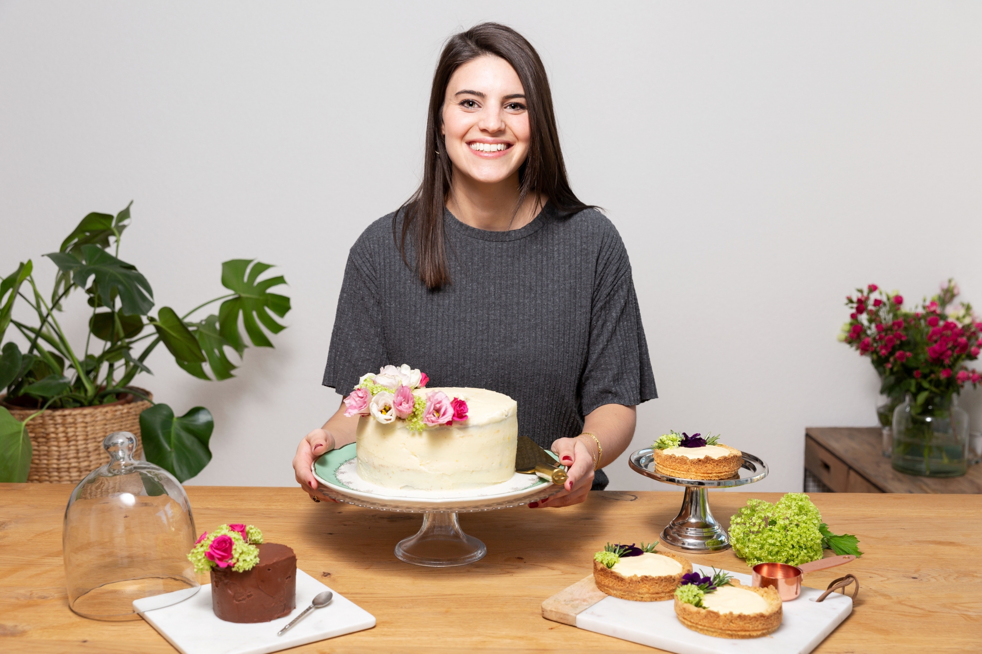 Bérangère Saudan devant deux versions de son gâteau monté (glaçage blanc et glaçage au chocolat) et ses tartelettes thym-citron