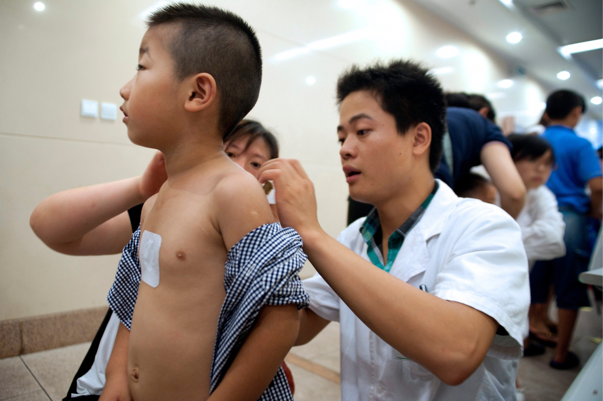 epa03309529 A doctor applies an ointment to a boy while receiving a traditional Chinese medical treatment named 'Winter Diseases Treated in Summer' at a hospital of Qingdao city, eastern China's Shandong province, 18 July 2012. This ancient tradition also called 'dong bing xia zhi' is a treatment that takes places during the summer or 30 hottest days of summer. The idea is build up the hot energy (yang) at this time of year when it is at its peak in the human body; this is believed to prevent or reduce winter ailments caused by the invasion of cold energy (yin) when yang is at a low level. The patients receive the treatments by point pasting with medical ointment on their body and moxibustion in order to cure tracheitis, asthma, rhinitis, rheumatoid arthritis and others winter diseases.  EPA/WU HONG CHINA ALTERNATIVMEDIZIN