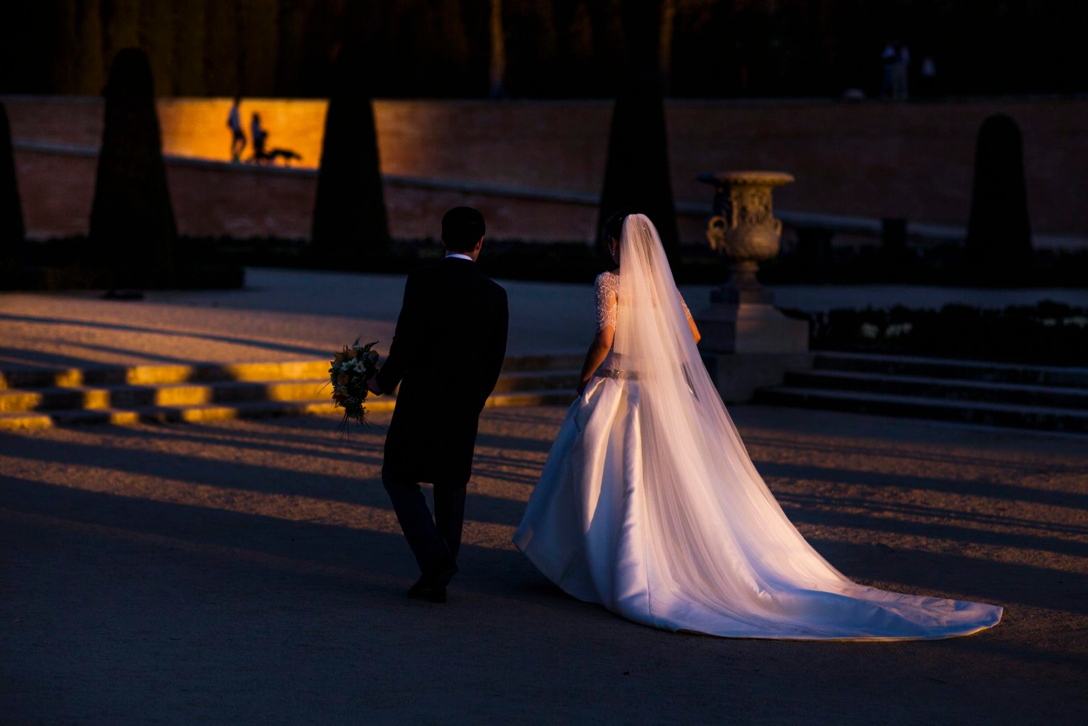 A married couple look for a location to take a wedding photo as people walk their dog during a sunset in Retiro Park in Madrid, Spain, Saturday, March 7, 2015. The Retiro Park, a beautifully tended 350-acre garden space where city-dwellers go to get away from the metropolitan hubbub lies in the heart of the city. Originally the formal gardens of a medieval palace, it became King Philip II's 16th-century refuge from court preoccupations, as well as his religious retreat. (AP Photo/Andres Kudacki) APTOPIX Spain Daily Life