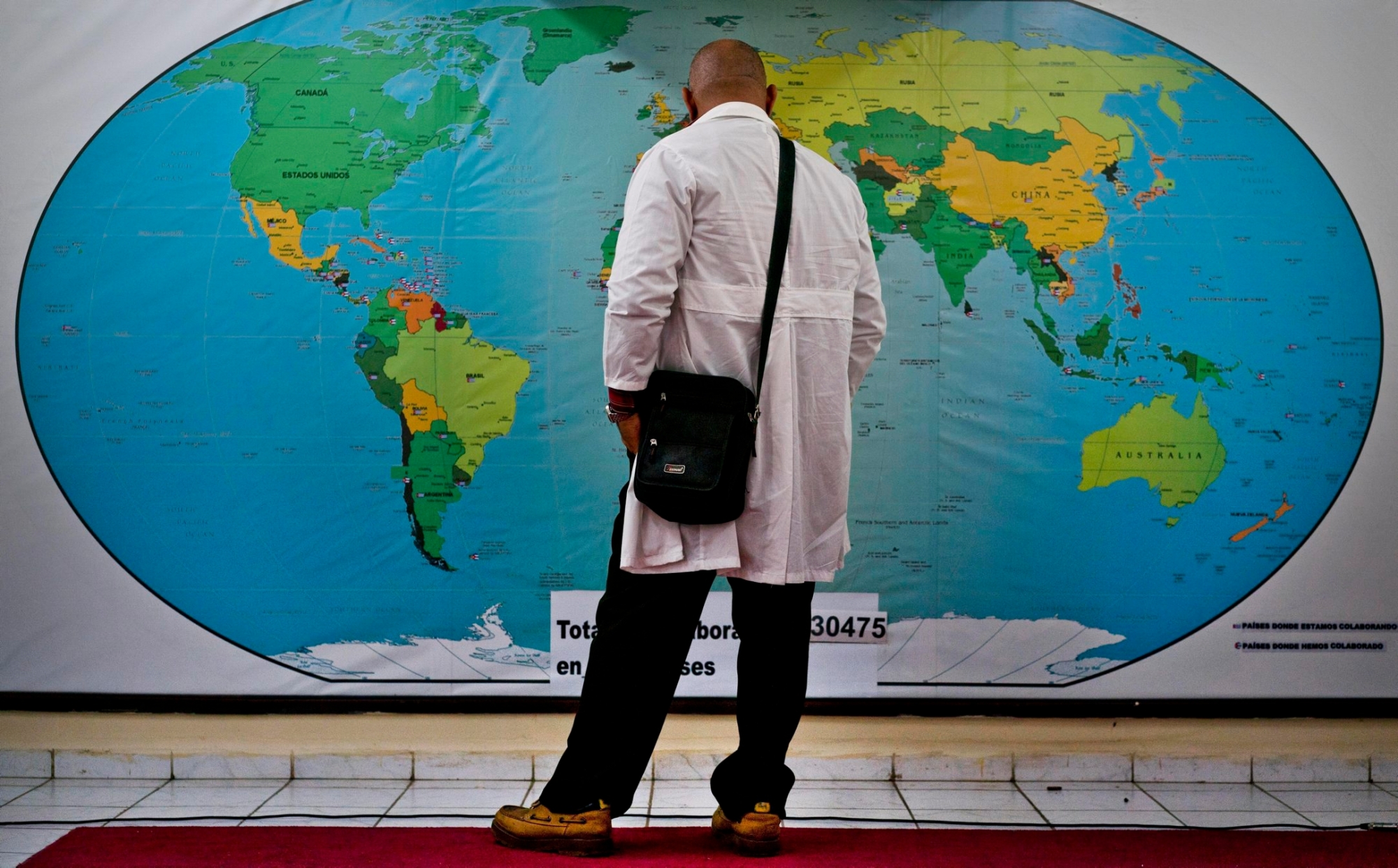 Cuban doctor Ralfis Carbort looks at a map of the world before leaving with the Henry Reeve contingent of Cuban doctors in solidarity with Mozanbique, to help with the devastation caused by Hurricane Idai, in Havana, Cuba, Tuesday, March 26, 2019. (AP Photo/Ramon Espinosa) CUBA MOZANBIQUE DOCTORS