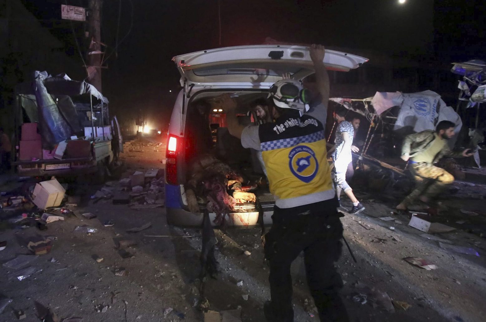 This photo provided Tuesday, May 21, 2019 by the Syrian Civil Defense group known as the White Helmets, shows Syrian White Helmet civil defense worker loading an injured man into an ambulance after Syrian government airstrikes hit the town of Maaret al-Numan, Idlib province, Syria. Syrian activists and a rebel spokesman said Wednesday that opposition fighters have recaptured Kfar Nabuda, a village at the edge of the last rebel stronghold in northwestern Syria. (Syrian Civil Defense White Helmets via AP) Syria