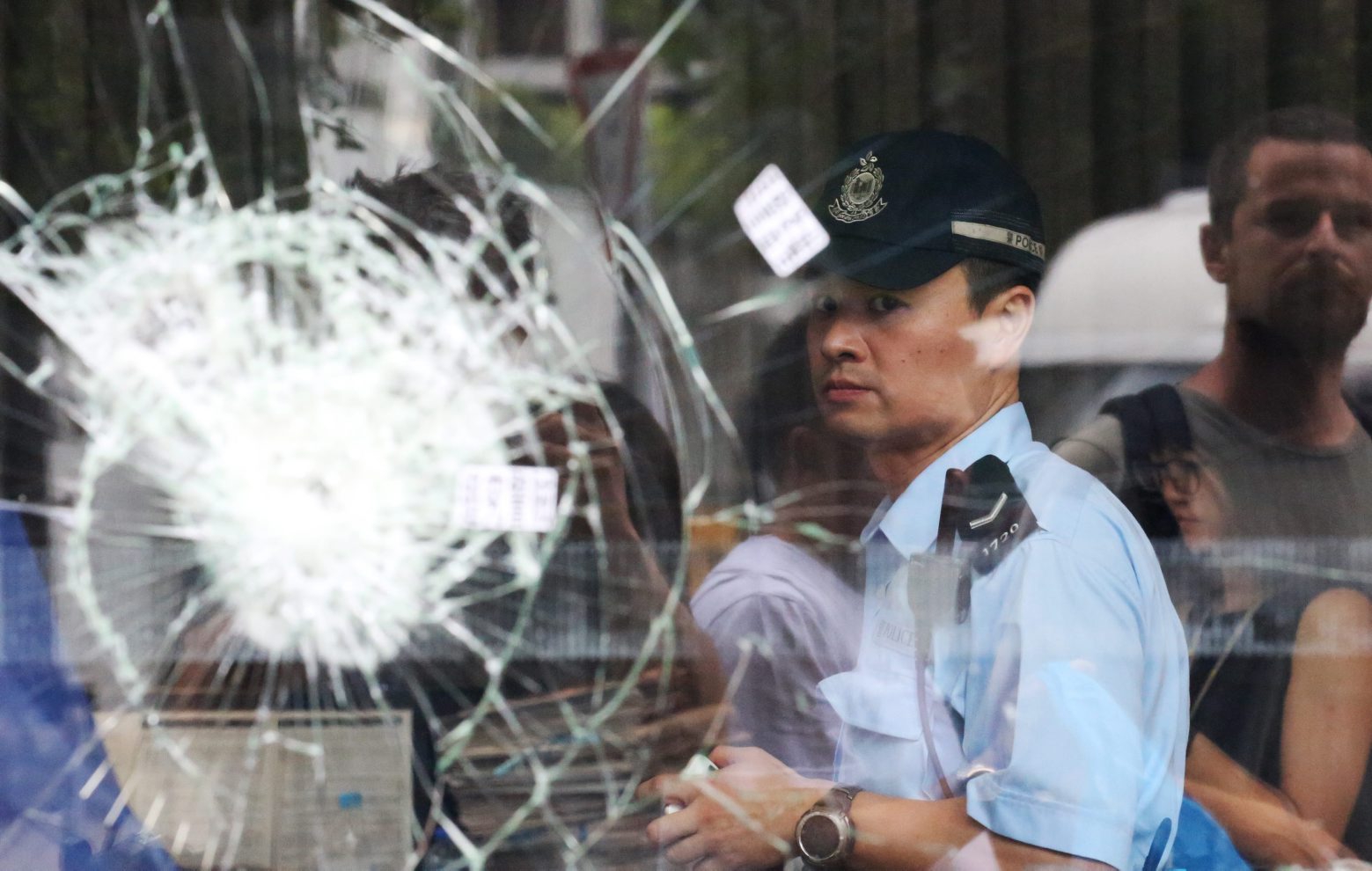epa07688545 Police officers are seen behind broken glass panels at the Legislative Council Building after protesters stormed the building in Hong Kong, China, 02 July 2019. According to reports, police fired tear gas and evicted protesters who broke into and occupied the Legislative Council Building for hours on 01 July 2019, the 22nd anniversary of the 1997 handover of Hong Kong from Britain to China.  EPA/RITCHIE B. TONGO CHINA HONG KONG EXTRADIITON BILL PROTEST