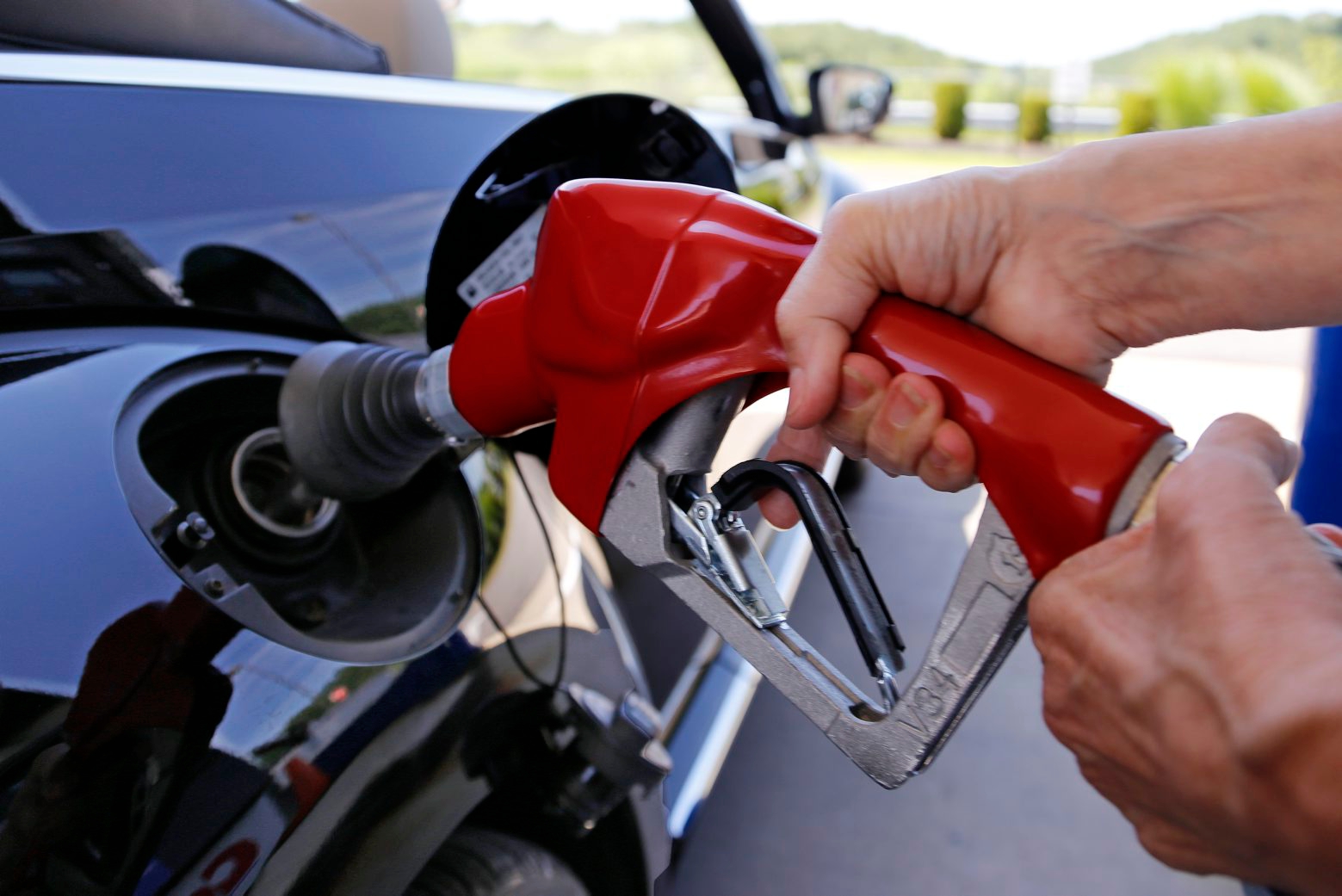 FILE - In this Thursday, July 16, 2015, file photo, a customer re-fuels her car at a Costco in Robinson Township, Pa. The plunging price of oil in 2016 is dragging stock markets to their worst start to a year ever, even though low fuel prices are great for consumers and most companies. (AP Photo/Gene J. Puskar, File) Oil Prices-Stock Market Slump-Q A