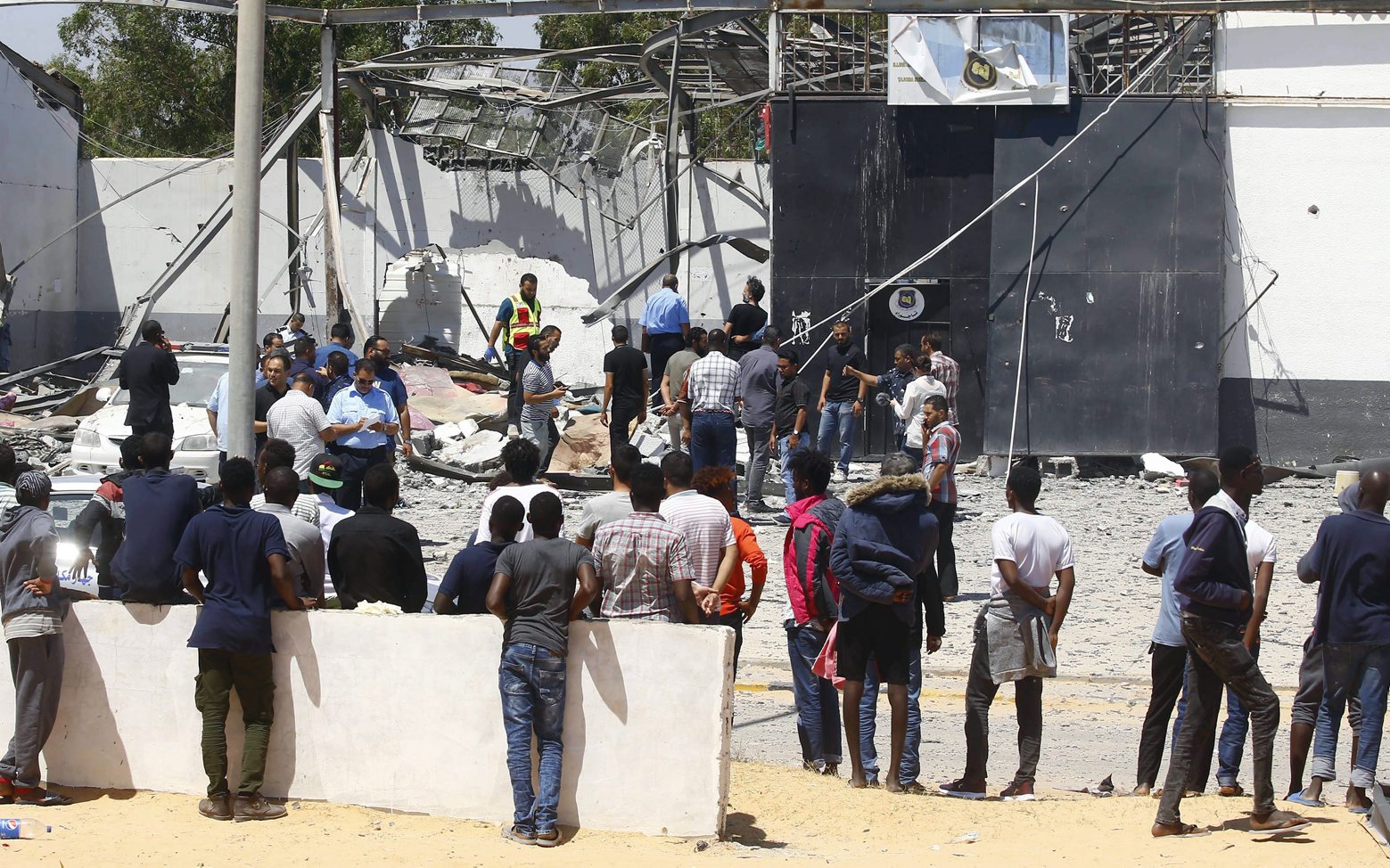 epa07692748 Migrants check the rubble of a destroyed detention center in Tripoli's, Libya, 03 July 2019. according to media reports, At least 44 people killed and 130 were injured after strike hit the Tajoura detention center held at least 600 refugees were attempting to reach Europe from Libya. The parties disputed didn't claimed any responsibility for the attack.  EPA/STR LIBYA DETENTION CENTRE