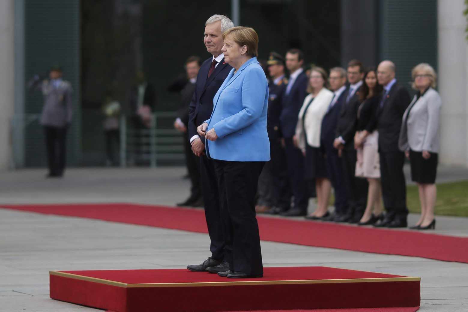German Chancellor Angela Merkel and Prime Minister of Finland Antti Rinne listen to the national anthems at the chancellery in Berlin, Germany, Wednesday, July 10, 2019. Merkel's body shook visibly as she stood alongside the Finnish prime minister and listen to the national anthems during the welcoming ceremony at the chancellery. (AP Photo/Markus Schreiber) Germany Finland Merkel