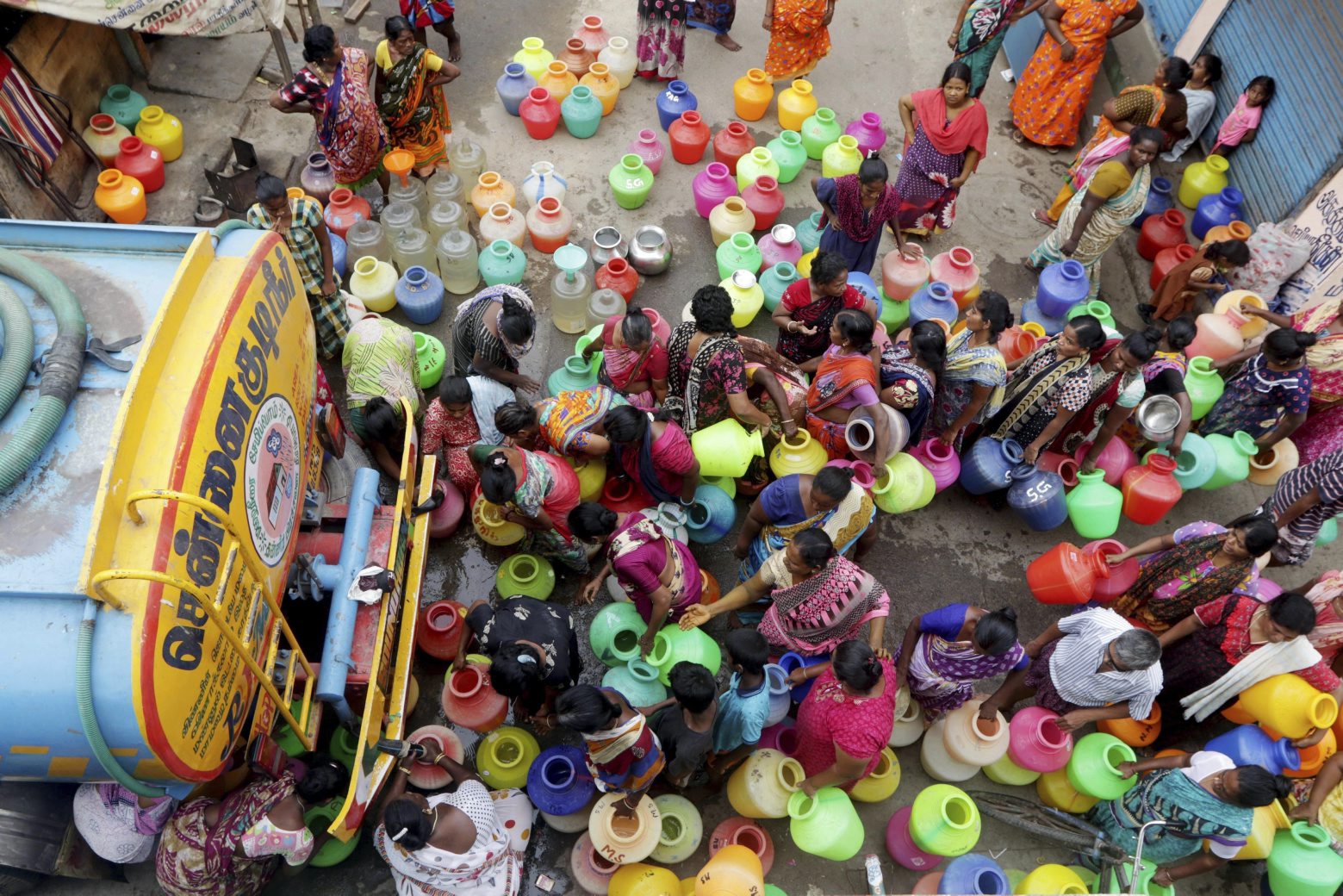 FILE- In this June 19, 2019, file photo, Indians stand in queues to fill vessels filled with drinking water from a water tanker in Chennai, capital of the southern Indian state of Tamil Nadu. With the government able to meet only 40% of water requirement, millions of people are depending on water tank trucks in the southern Indian state of Tamil Nadu because of an acute water shortage caused by drying lakes and deplete groundwater. (AP Photo/R. Parthibhan, File) India Water Shortage
