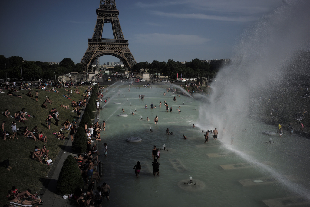 Des gens se rafraîchissent dans les fontaines des jardins du Trocadéro, devant la Tour Eiffel, à Paris.