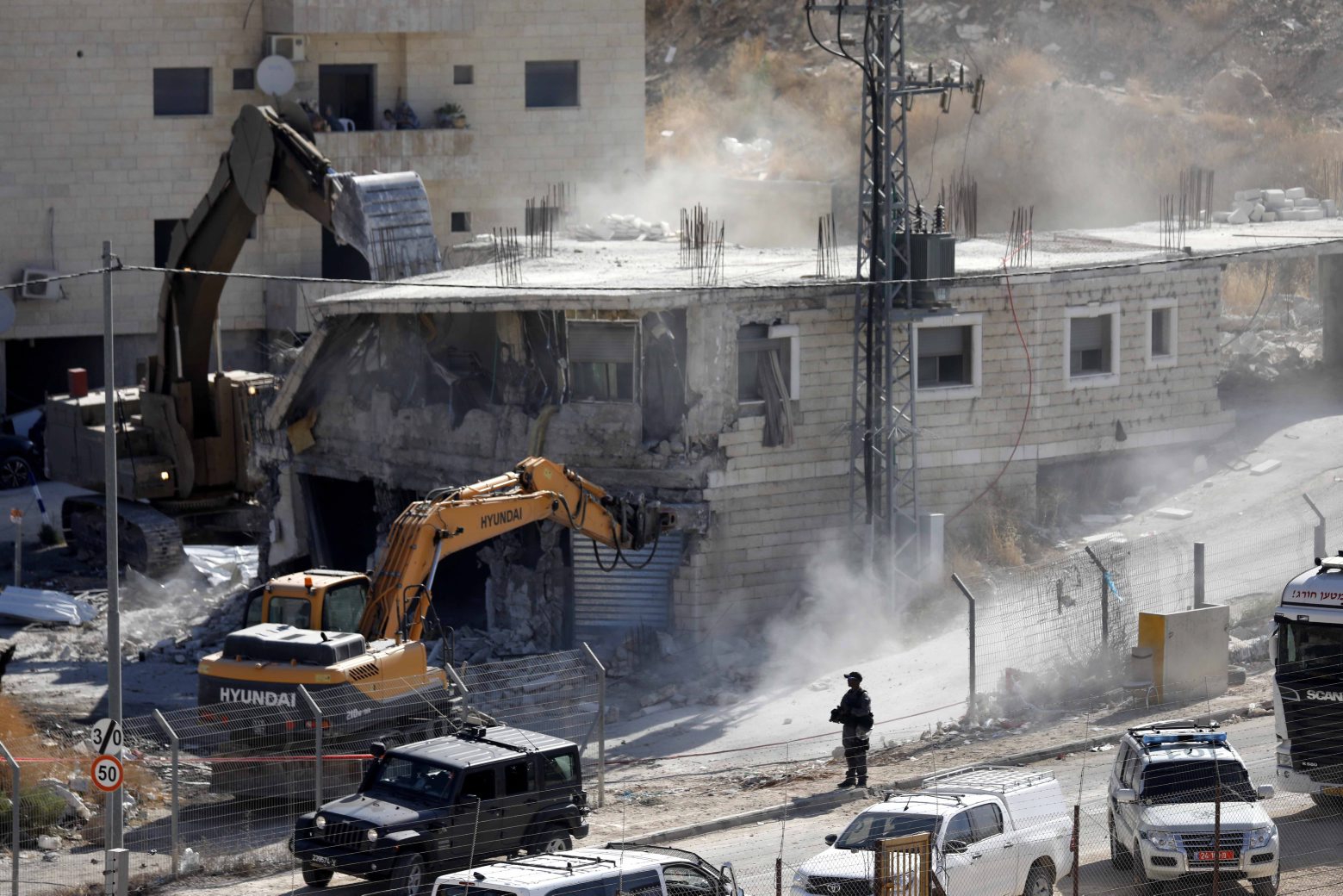 epa07732780 An Israeli army bulldozer demolishes a building in the Palestinian village of Sur Baher, in East Jerusalem, 22 July 2019. Israeli authorities decided to demolish at least six Palestinian residential buildings housing hundreds of Palestinian families, because they are located near the Israeli separation wall.  EPA/ABED AL HASHLAMOUN MIDEAST PALESTINIANS ISRAEL BUILDING DEMOLITION