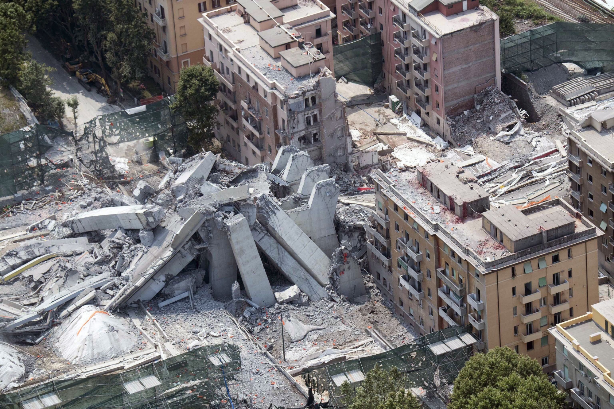An aerial view of the remains of the Morandi bridge in Genoa, Italy, Saturday, June 29, 2019. A spectacular planned explosion Friday knocked down the remaining spans and supporting columns of the Italian bridge that collapsed last year, killing 43 people. (Luca Zennaro/ANSA via AP) ITALY GENOA BRIDGE