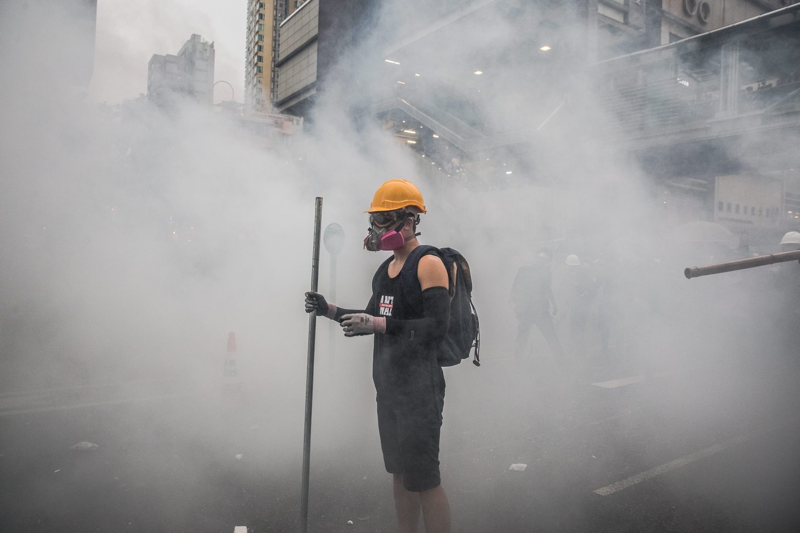 epa07793171 A protester wearing a gas mask stands in a tear gas smoke fired by the police during an anti-government rally in Tsuen Wan, in Hong Kong, China, 25 August 2019. The protests were triggered by an extradition bill to China in June, now suspended, and evolved into a wider anti-government movement with no end in sight.  EPA/ROMAN PILIPEY CHINA HONG KONG PROTESTS