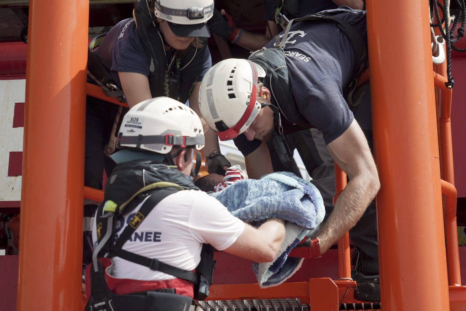 A newborn baby is carried onto the Ocean Viking humanitarian rescue ship after a rescue operation some 53 nautical miles (98 kilometers) from the coast of Libya in the Mediterranean Sea, Tuesday, Sept. 17, 2019. The humanitarian rescue ship Ocean Viking pulled 48 people from a small and overcrowded wooden boat including a newborn and a pregnant woman. (AP Photo/Renata Brito) Europe Migrants