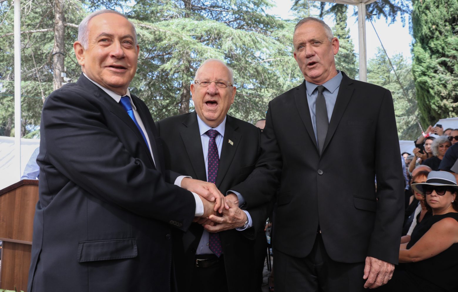 epa07852802 (L-R) Israeli Prime Minister Benjamin Netanyahu, Israeli President Reuven Rivlin and Benny Gantz, former Israeli Army Chief of Staff and chairman of the Blue and White Israeli centrist political alliance join hands as they attend a memorial service for late Israeli president Shimon Peres at Mount Herzl, Israel's national cemetery, in Jerusalem, 19 September 2019.  EPA/ABIR SULTAN ISRAEL ELECTIONS