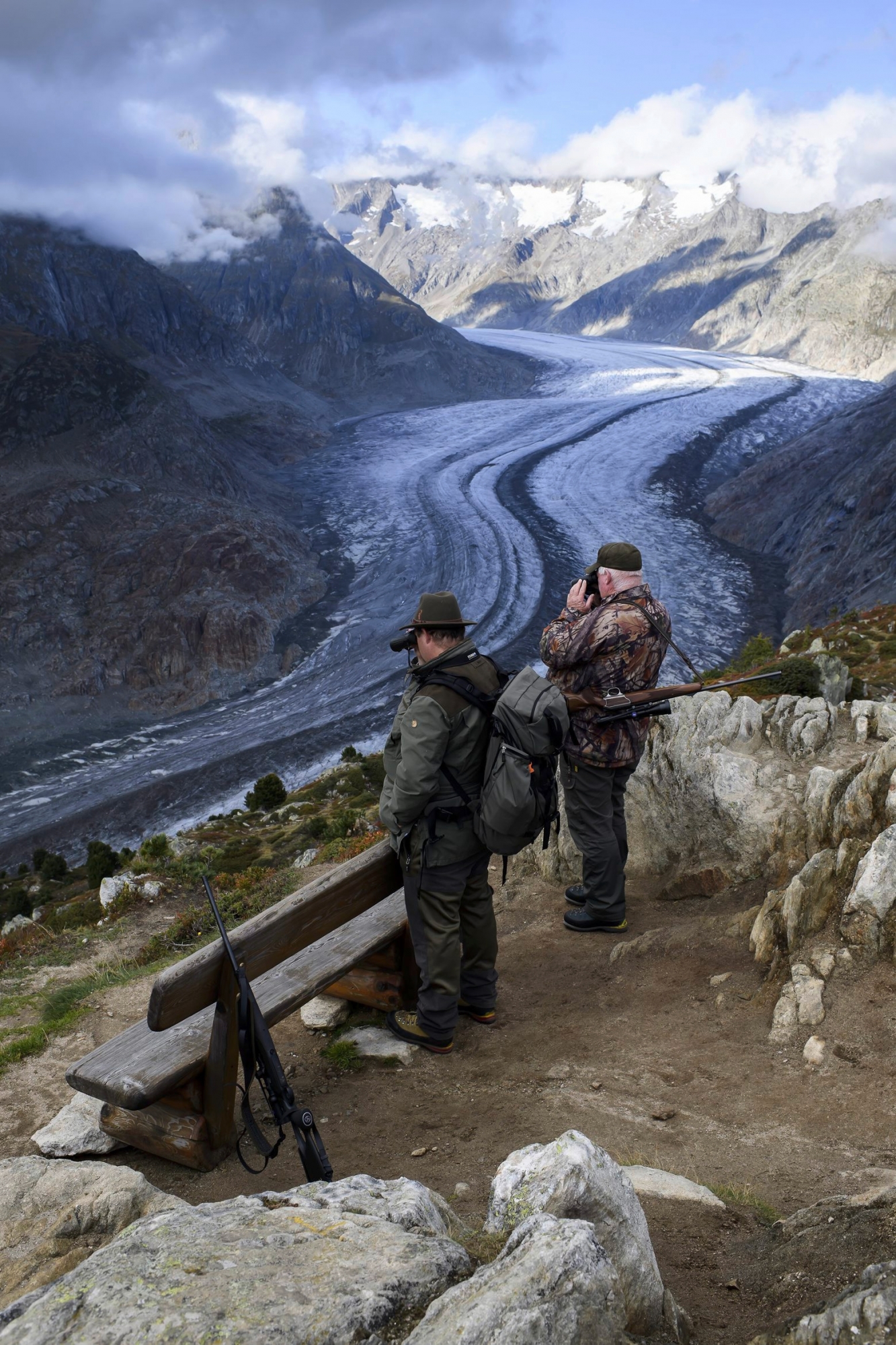 Two Hunters observe the wildlife next to the Swiss Aletsch Glacier during an autumn day above Bettmeralp in Wallis, Switzerland, on Monday, 23 September 2019. The Swiss Aletsch glacier, one of the largest ice streams in Europe, is the first Unesco World Heritage Site of the Alps. This huge river of ice that stretches over 23 km from its formation in the Jungfrau region (at 4000 m) down to the Massa Gorge in Wallis, around 2500 m below, fascinates and inspires every visitor. (KEYSTONE/Anthony Anex) SCHWEIZ ALETSCHGLETSCHER