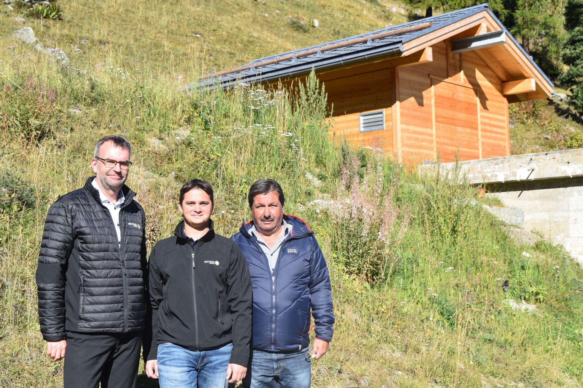 A Siviez, Bastien Moesching, chef de projet, Francis Dumas, président de la commune de Nendaz et Philippe Délèze, directeur de SEIC-Télédis présentent l'une des nouvelles stations de turbinage de Nendaz.