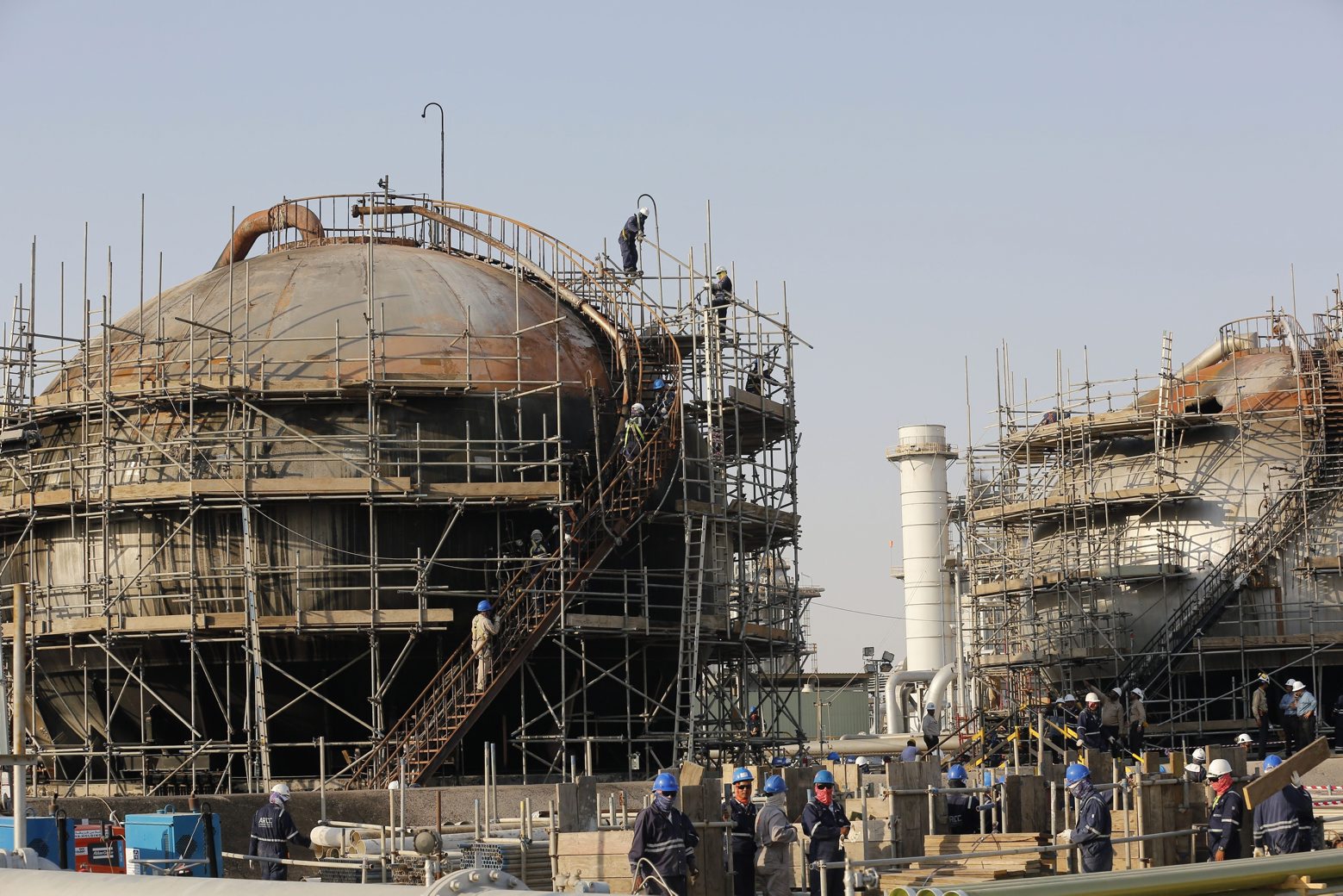 FILE- In this Sept. 20, 2019 file photo taken during a trip organized by Saudi information ministry, workers fix the damage in Aramco's oil separator at processing facility after the recent Sept. 14 attack in Abqaiq, near Dammam in the Kingdom's Eastern Province. Saudi Arabia has formally announced the start of its initial public offering of the state-run oil giant Saudi Aramco. (AP Photo/Amr Nabil, File) Saudi Arabia Aramco