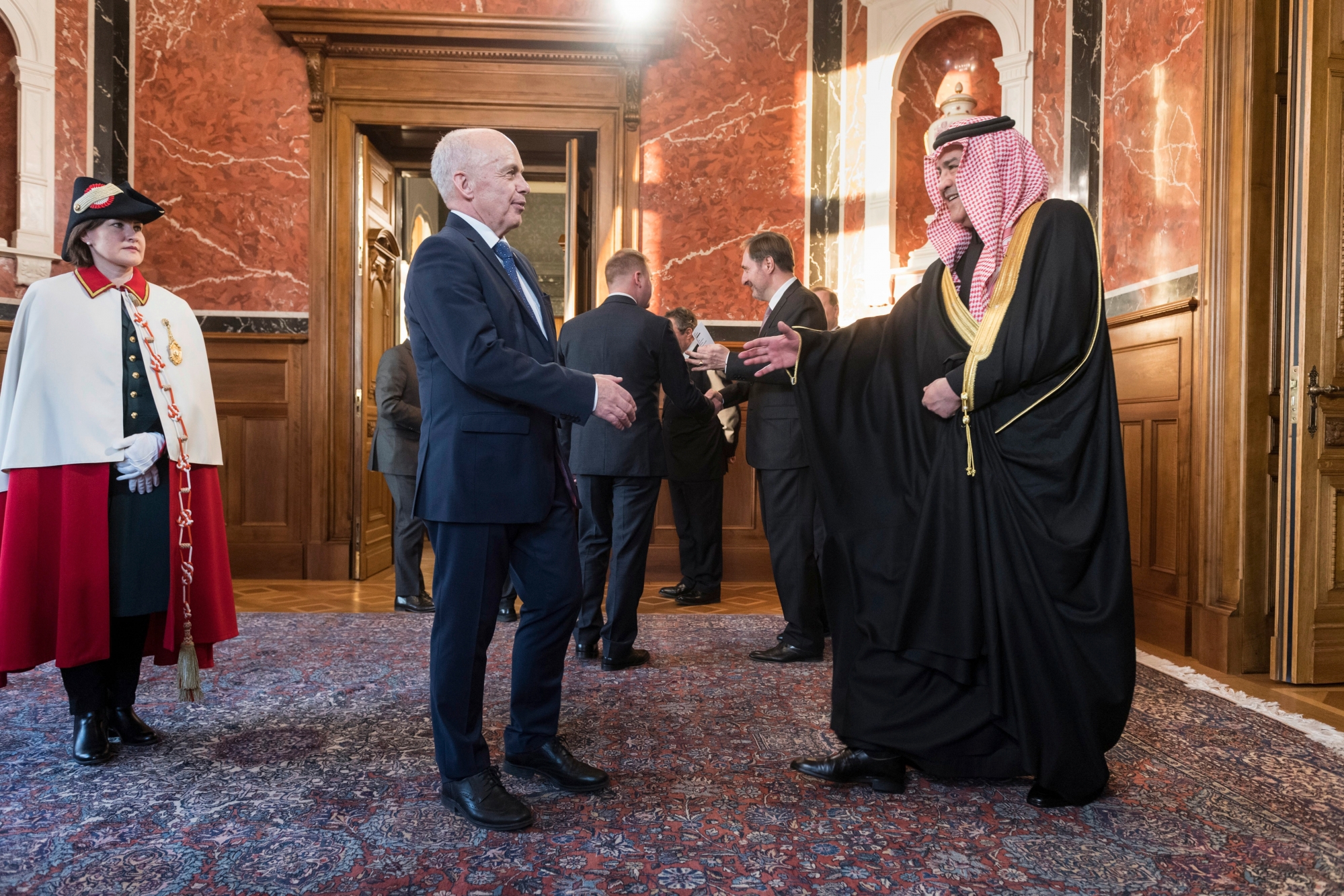 Swiss president Ueli Maurer, center, greets greets Hisham Alqahtani, ambassador of Saudi Arabia, right, during the traditional New YearÕs reception of the diplomatic corps, Wednesday, January 16, 2019 in the Federal palace in Bern. The ceremony is attended by the ambassadors, charges d'affaires, presidents of the National Council and Council of States, chairs of both councilsÕ foreign affairs committees and the authorities of the city and canton of Bern. Far left, Maurer's usher Maria Wisler. (KEYSTONE/Alessandro della Valle) SWITZERLAND NEW YEAR'S GREETINGS DIPLOMATIC CORPS