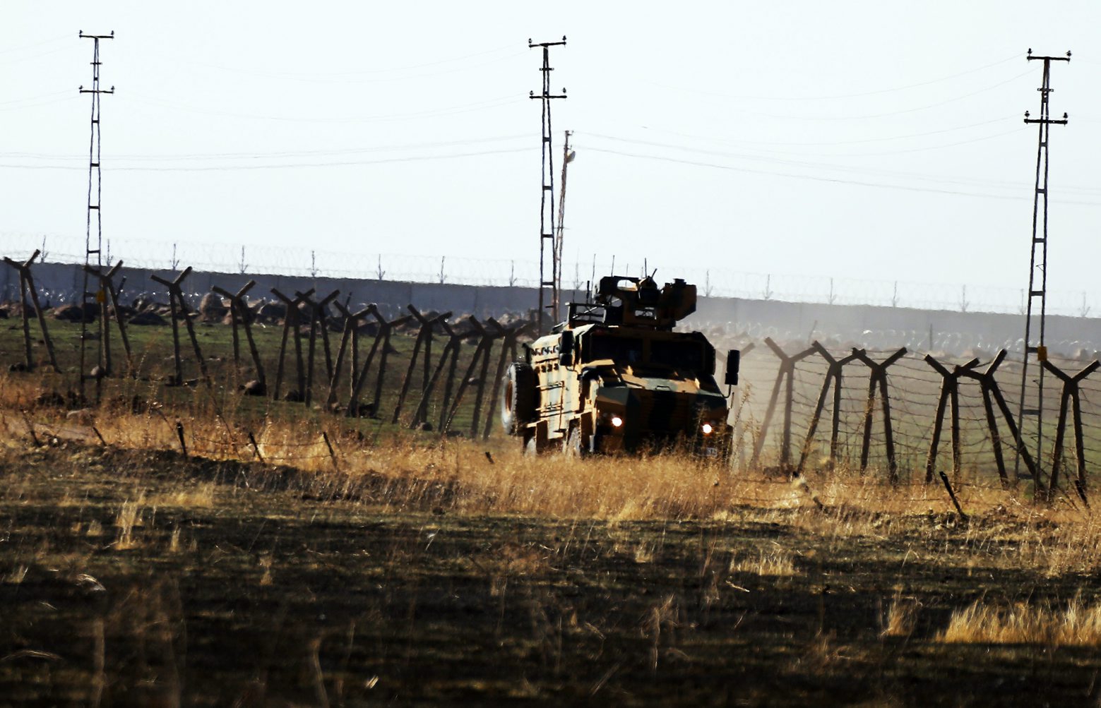 In this photo taken from the outskirts of the village of Alakamis, in Idil province, southeastern Turkey, a Turkish army vehicles is driven in Turkey after conducting a joint patrol with Russian forces in Syria, Friday, Nov. 8, 2019. The Britain-based Syrian Observatory for Human Rights says a protester has been killed when he was run over in the village of Sarmasakh, Syria near the border by a Turkish vehicle during a joint patrol with Russia.The man was among residents who pelted with shoes and stones Turkish and Russian troops who were conducting their third joint patrol in northeastern Syria, under a cease-fire deal brokered by Moscow that forced Kurdish fighters to withdraw from areas bordering Turkey. (AP Photo/Mehmet Guzel) Turkey Russia Syria