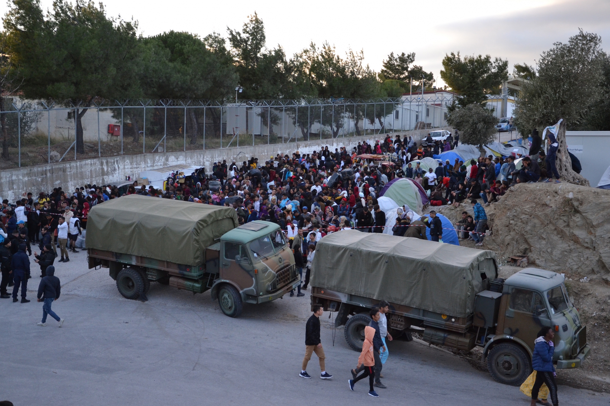 epa07965453 Refugees wait outside the hotspot in Moria, Lesvos island, Greece, 01 November 2019, to be transferred by navy ships to the mainland Greece. Over 1,000 asylum applicants will be transferred from NE Aegean islands to the mainland in the next three days. According to sources speaking to Athens-Macedonian News Agency, all refugees will be distributed evenly in the mainland Greece. Two navy ships carrying 800 individuals from Lesvos will arrive at Elefsina port on 02 November, while another 100 will be transferred from Samos to Piraeus port on 03 November and another 130 asylum applicants will arrive in Piraeus the next days from Chios, Kos and Leros islands.  EPA/STRATIS BALASKAS GREECE LESVOS ISLAND REFUGEES