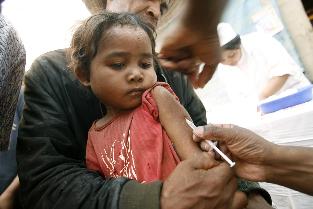 Un enfant reçoit un vaccin dans une clinique villageoise improvisée, à Madagascar. L'île est un des cinq pays à avoir concentré près de la moitié des cas de rougeole en 2018.