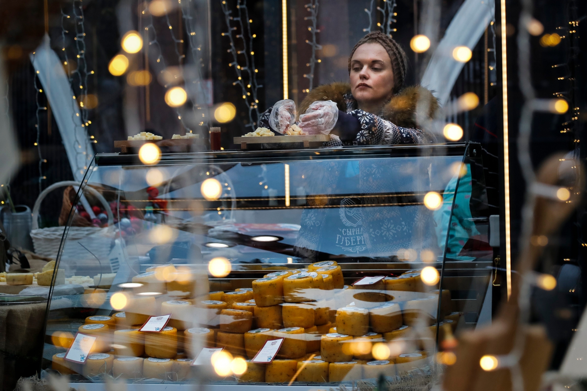 A saleswoman stands behind a counter with Russian-made cheese in downtown Moscow, Russia on Friday, Dec. 30, 2016. (AP Photo/Alexander Zemlianichenko) RUSSLAND MOSKAU