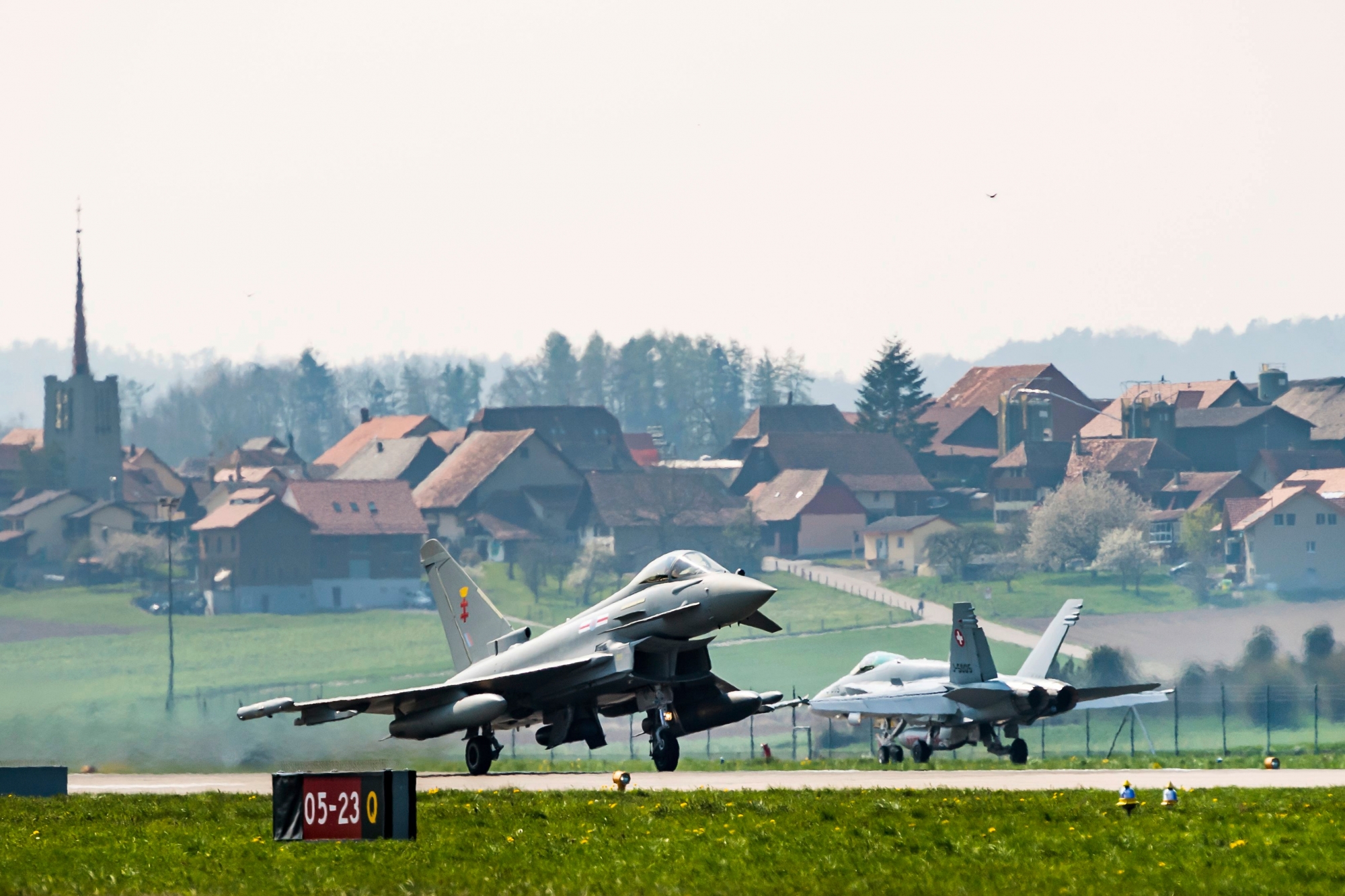A Airbus Eurofighter jet takes off next to a Swiss Air Force F/A-18 Hornet during a evaluating day at the Swiss Army airbase, in Payerne, Switzerland, Friday, April 12, 2019. (KEYSTONE/Jean-Christophe Bott) SWITZERLAND EUROFIGHTER JET