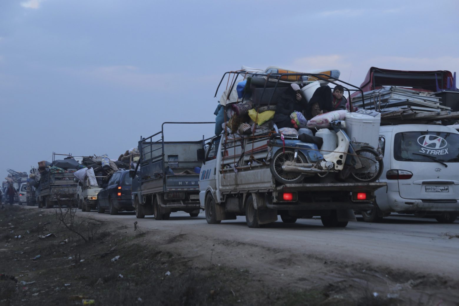 Truckloads of civilians flee a Syrian military offensive in Idlib province on the main road near Hazano, Syria, Tuesday, Dec. 24, 2019. Syrian forces launched a wide ground offensive last week into the northwestern province of Idlib, which is dominated by al-Qaida-linked militants. The United Nations estimates that some 60,000 people have fled from the area, heading south, after the bombings intensified earlier this month. (AP Photo/Ghaith al-Sayed) Syria