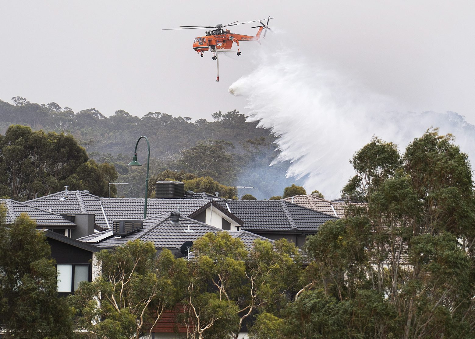 epaselect epa08094624 A Skycrane drops water on a bushfire in Bundoora, Melbourne, Australia, 30 December 2019. According to local media reports, thousands of residents and tourists were forced to evacuate in the state of Victoria as soaring temperatures and winds fanned several bushfires around the state.  EPA/ELLEN SMITH AUSTRALIA AND NEW ZEALAND OUT epaselect AUSTRALIA BUSHFIRES