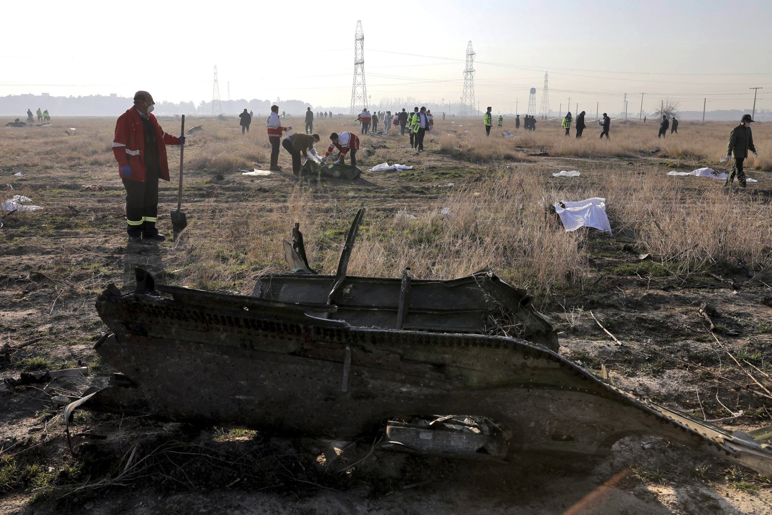 In this Wednesday, Jan. 8, 2020 photo, rescue workers search the scene where a Ukrainian plane crashed in Shahedshahr, southwest of the capital Tehran, Iran. Iran on Friday denied Western allegations that one of its own missiles downed a Ukrainian jetliner that crashed outside Tehran, and called on the U.S. and Canada to share any information they have on the crash, which killed all 176 people on board. (AP Photo/Ebrahim Noroozi) Iran Plane Crash