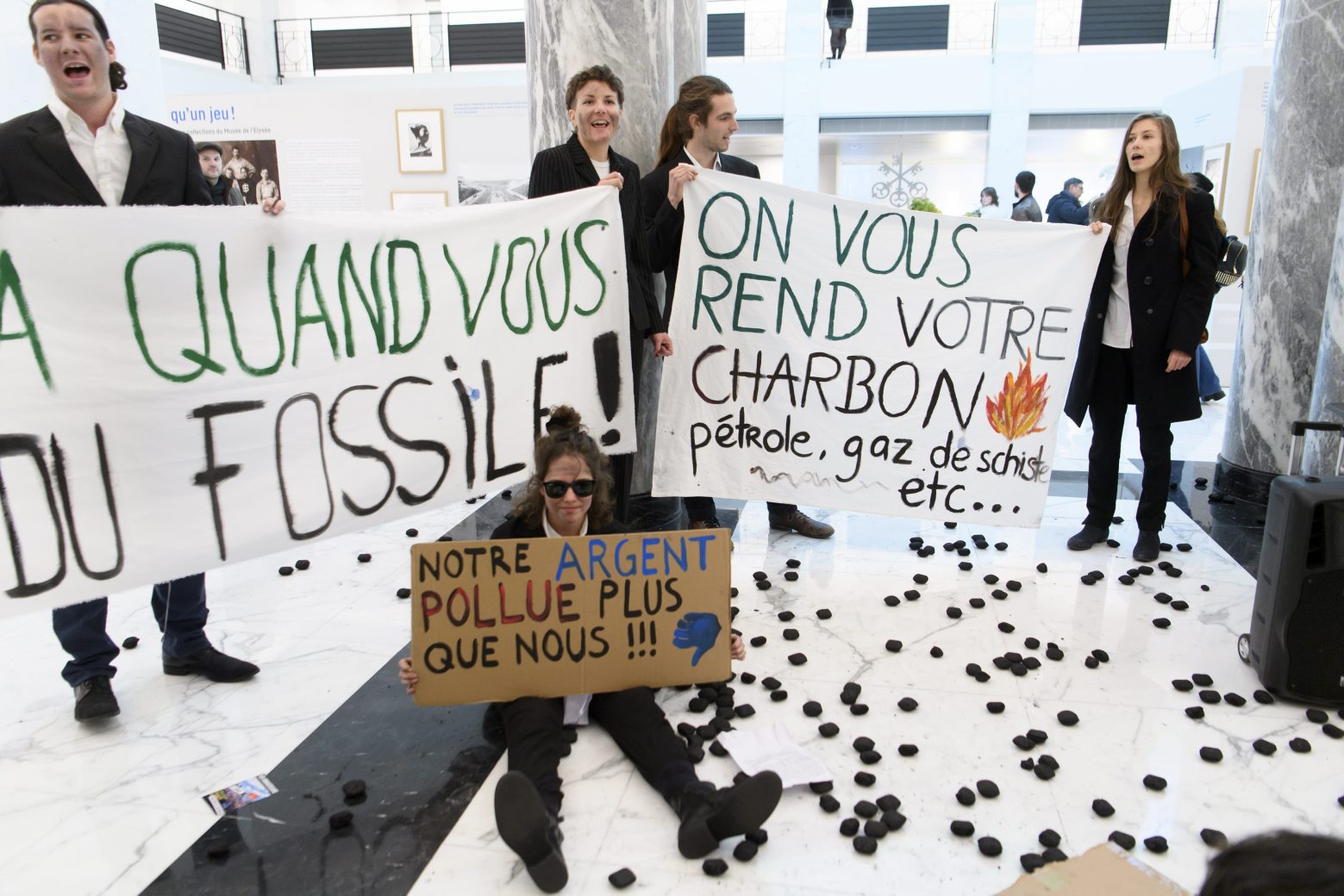 Pro-climate activists of the Climate Strike (Greve du Climat Vaud) collective demonstrate during a environmental protest inside of a branch of Swiss bank UBS, in Lausanne, Switzerland, Tuesday, January 14, 2020. (KEYSTONE/Laurent Gillieron) SWITZERLAND UBS BANK PRO CLIMATE ACTIVISTS