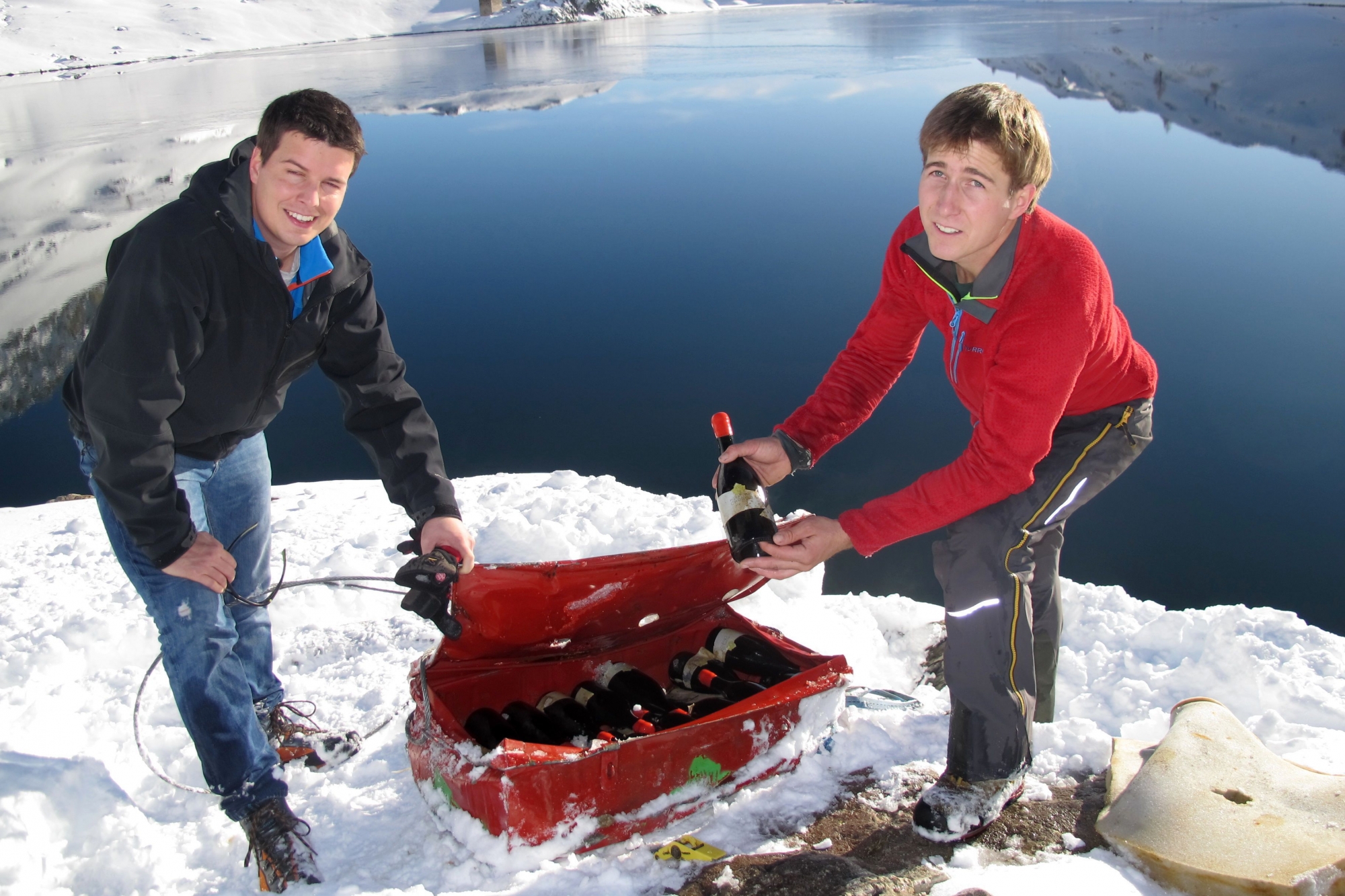 Sur les bords du Grand Lac de Sorniot, le vigneron Pierre-Elie Carron (à dr.) et le responsable de l'Office du tourisme de Fully Alexandre Roduit découvrent les bouteilles de petite arvine après leur séjour d'un an dans l'eau.