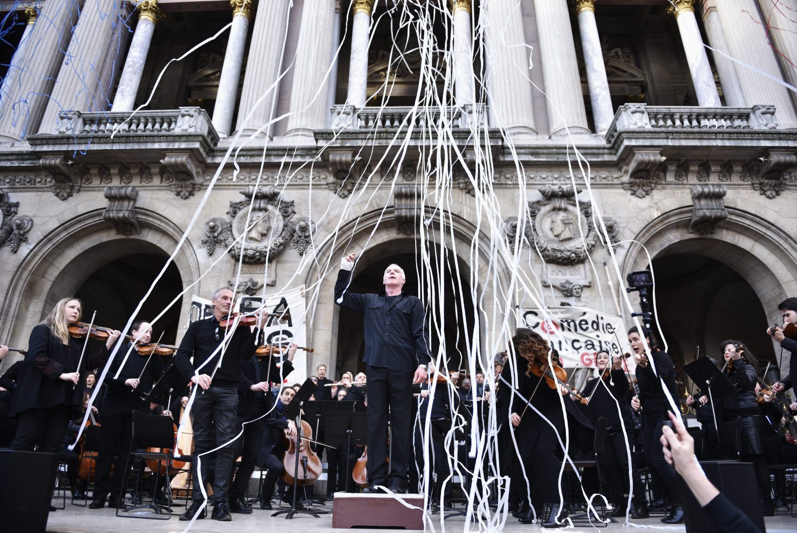 epa08138777 French National Opera song director Michel Dietlin (C) performs with musicians of the orchestra outside the Palais Garnier opera house during a demonstration in front of the National Opera in Paris, France, 18 January 2020. France faces an ongoing national strike against the French government's pensions reform for the 45th days consecutive.  EPA/JULIEN DE ROSA FRANCE GENERAL STRIKE