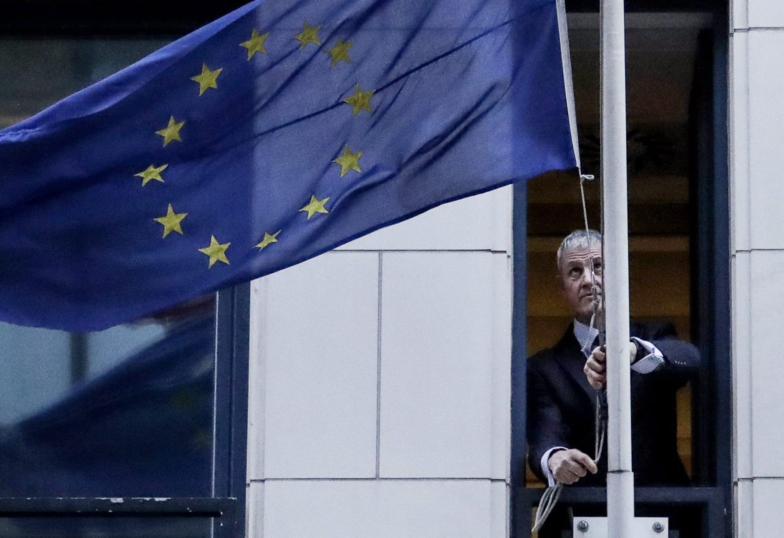 epaselect epa08182520 A man removes the European Union flag from the UK representation to the EU in Brussels, Belgium, 31 January 2020. Britain officially exits the EU on 31 January 2020, beginning an eleven month transition period.  EPA/OLIVIER HOSLET / POOL epaselect BELGIUM EU BREXIT FLAG REMOVAL
