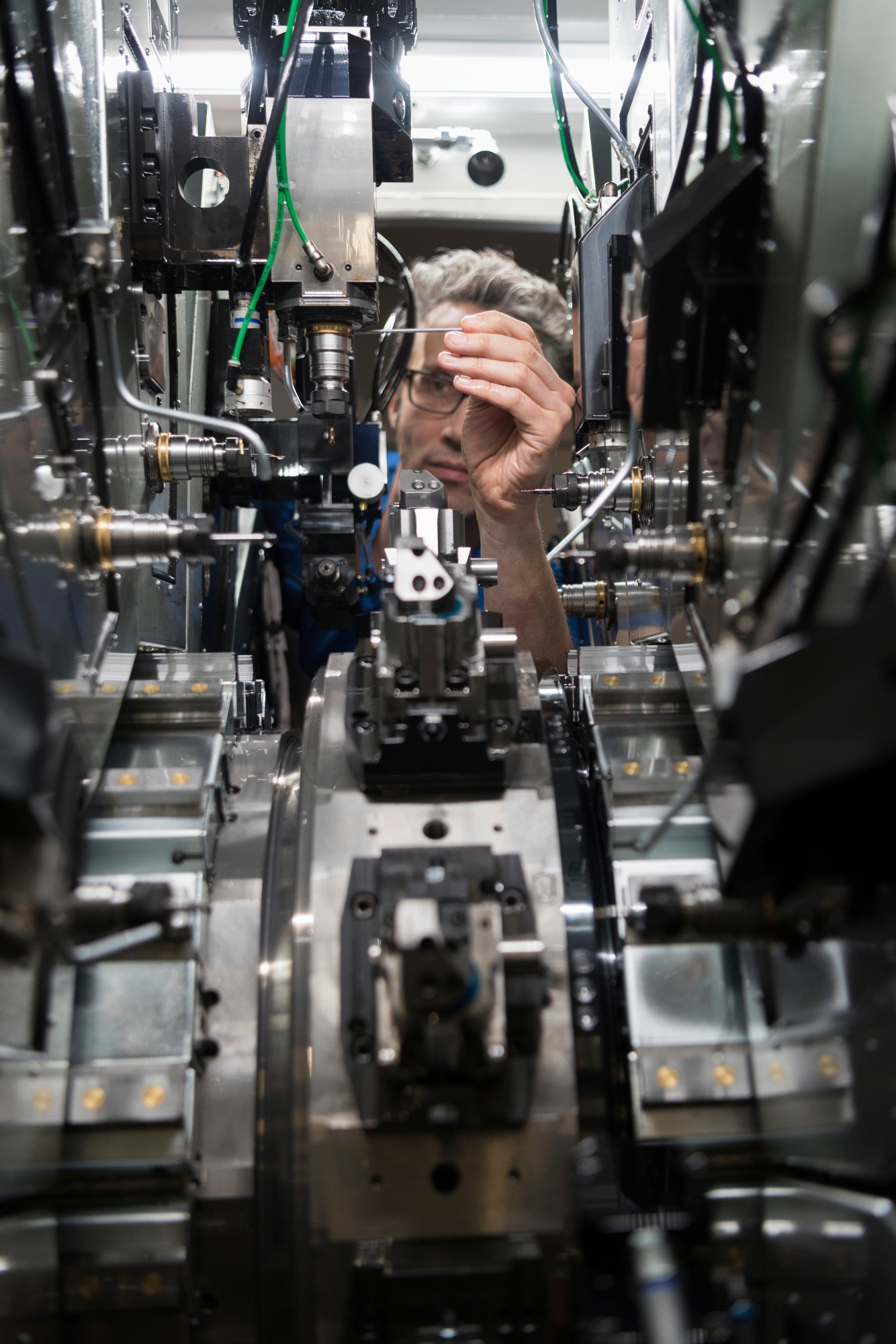 An employee works on a machine at the Mikron Machining production site of the Mikron Group in Agno, Canton of Ticino, Switzerland, on January 24, 2019. The engineering company Mikron Group develops, produces and markets automation solutions as Mikron Automation in Boudry, Canton of Neuchatel, as well as machining systems as Mikron Machining and cutting tools, as Mikron Tool, in Agno, besides various production sites abroad. (KEYSTONE/Christian Beutler) SCHWEIZ AGNO MIKRON