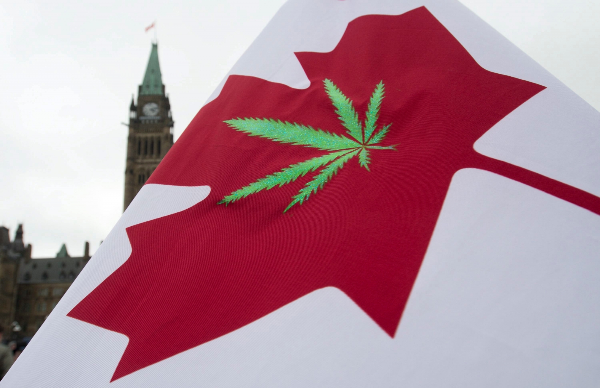 FILE - In this April 20, 2015 file photo, a Canadian flag with a cannabis leaf flies on Parliament Hill during a 4/20 protest in Ottawa, Ontario. Canada is following the lead of Uruguay in allowing a nationwide, legal marijuana market, although each Canadian province is working up its own rules for pot sales. The federal government and the provinces also still need to publish regulations that will govern the cannabis trade. (Adrian Wyld/The Canadian Press via AP, File) Canada Marijuana Legalization-Things to Know