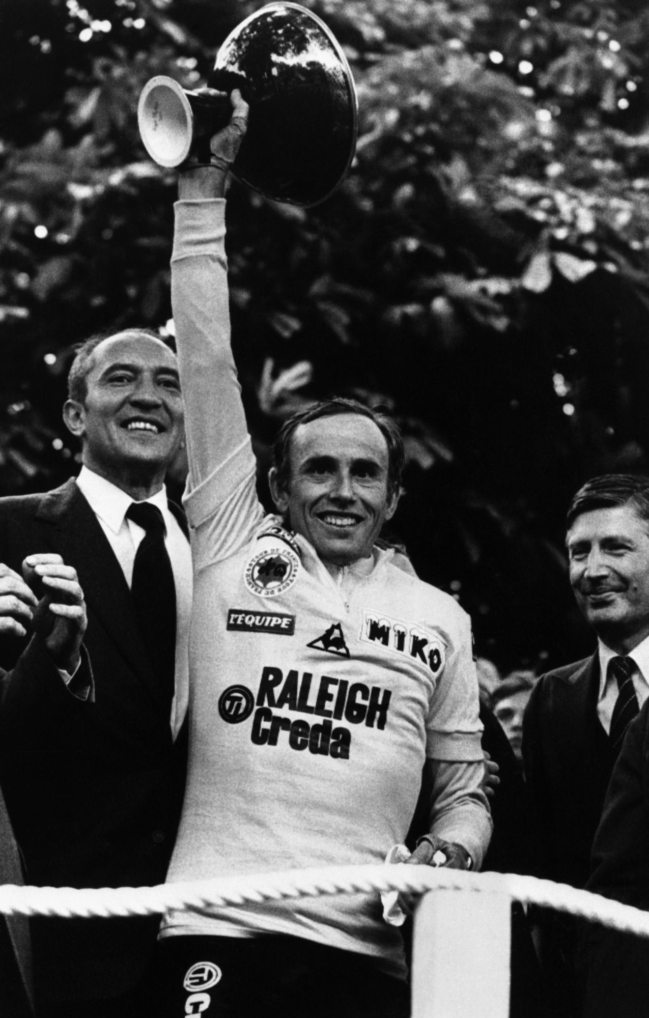 Joop Zoetemelk brandit le trophée du vainqueur lors de sa victoire au classement général du Tour de France en 1980. 