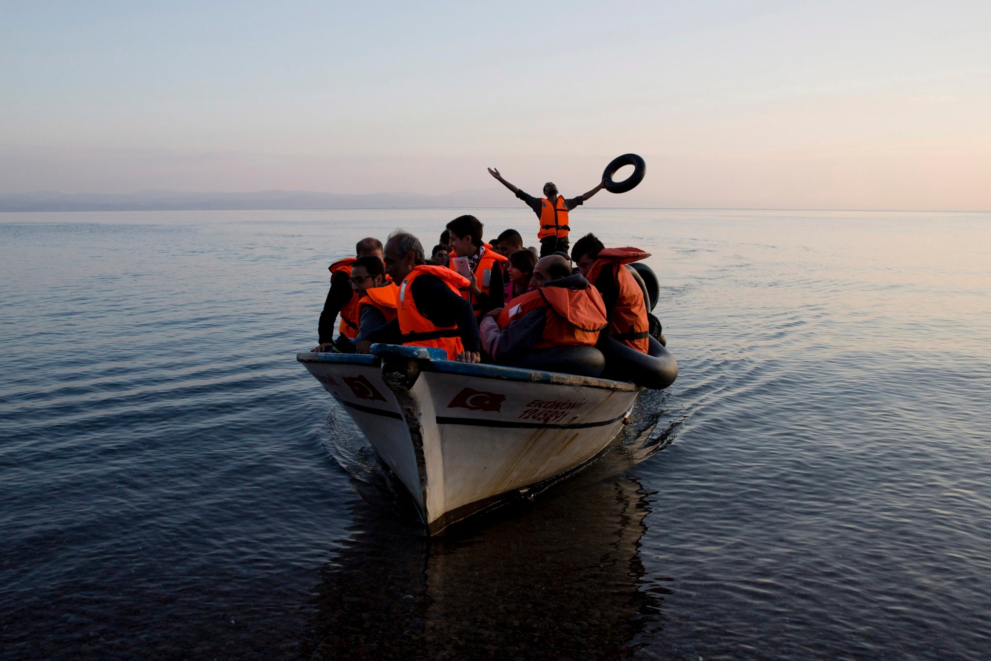 ARCHIV -- ZUM TAGESGESCHAEFT DER WINTERSESSION, AM  DIENSTAG, 11. DEZEMBER 2018, STELLEN WIR IHNEN FOLGENDES THEMENBILD ZUR VERFUEGUNG -- FOR USE AS DESIRED, YEAR END PHOTOS - FILE - A Syrian refuggee praises god as he arrive with others from Turkey on the shores of the Greek island of Lesbos, on a fishing boat, Sunday Sept. 27, 2015. More than 260,000 asylum-seekers have arrived in Greece so far this year, most reaching the country's eastern islands on flimsy rafts or boats from the nearby Turkish coast.(AP Photo/Petros Giannakouris, File) SCHWEIZ WINTERSESSION UNO MIGRATIONSPAKT