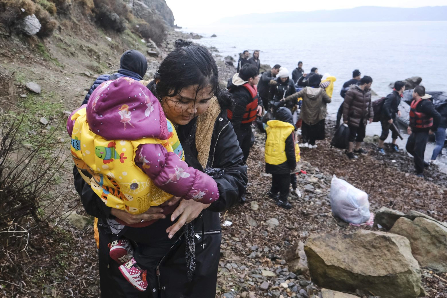 A migrant woman holds a baby after reaching the Greek island of Lesbos, after crossing on a dinghy the Aegean sea from Turkey on Thursday, March 5, 2020. Turkey said Thursday it would deploy special forces along its land border with Greece to prevent Greek authorities from pushing back migrants trying to cross into Europe, after Turkey declared its previously guarded gateways to Europe open. (AP Photo/Alexandros Michailidis) Greece Turkey Migrants