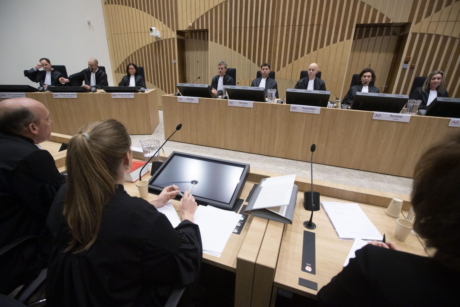 Lawyers Boudewijn van Eijck, left, and Sabine ten Doesschate, second left, lawyers for one of the four accused, judges, rear right, and the public prosecution, rear left, are seen at the start of the trial of four men charged with murder over the downing of Malaysia Airlines flight 17, at Schiphol airport, near Amsterdam, Netherlands, Monday, March 9, 2020. A missile fired from territory controlled by pro-Russian rebels in Ukraine in 2014, tore the MH17 passenger jet apart killing all 298 people on board. (AP Photo/Peter Dejong) Netherlands Ukraine Plane