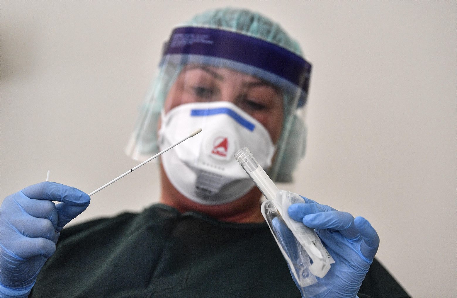 A nurse demonstrates taking a sample for a coronavirus test at the infection station of the university hospital in Essen, Germany, Thursday, March 12, 2020. The vast majority of people recover from the new coronavirus. According to the World Health Organization, most people recover in about two to six weeks, depending on the severity of the illness. (AP Photo/Martin Meissner) Germany Virus Outbreak