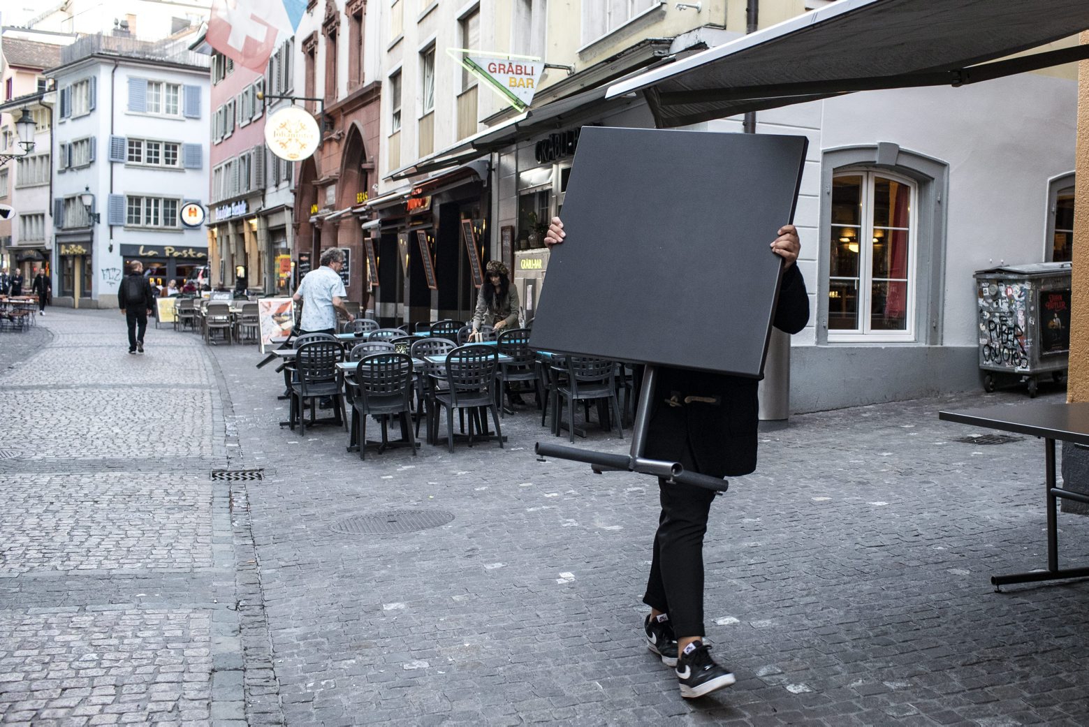 Ein Mann traegt einen Tisch in eine Bar im Niederdorf in Zuerich am Montag, 16. Maerz 2020. Der Bundesrat hat den den nationalen Notstand erklärt. Ab Mitternacht sind öffentliche und private Veranstaltungen verboten. Alle Laeden, Maerkte, Restaurants, Bars sowie Unterhaltungs- und Freizeitbetriebe werden geschlossen. (KEYSTONE/Alexandra Wey) SCHWEIZ ZUERICH CORONAVIRUS