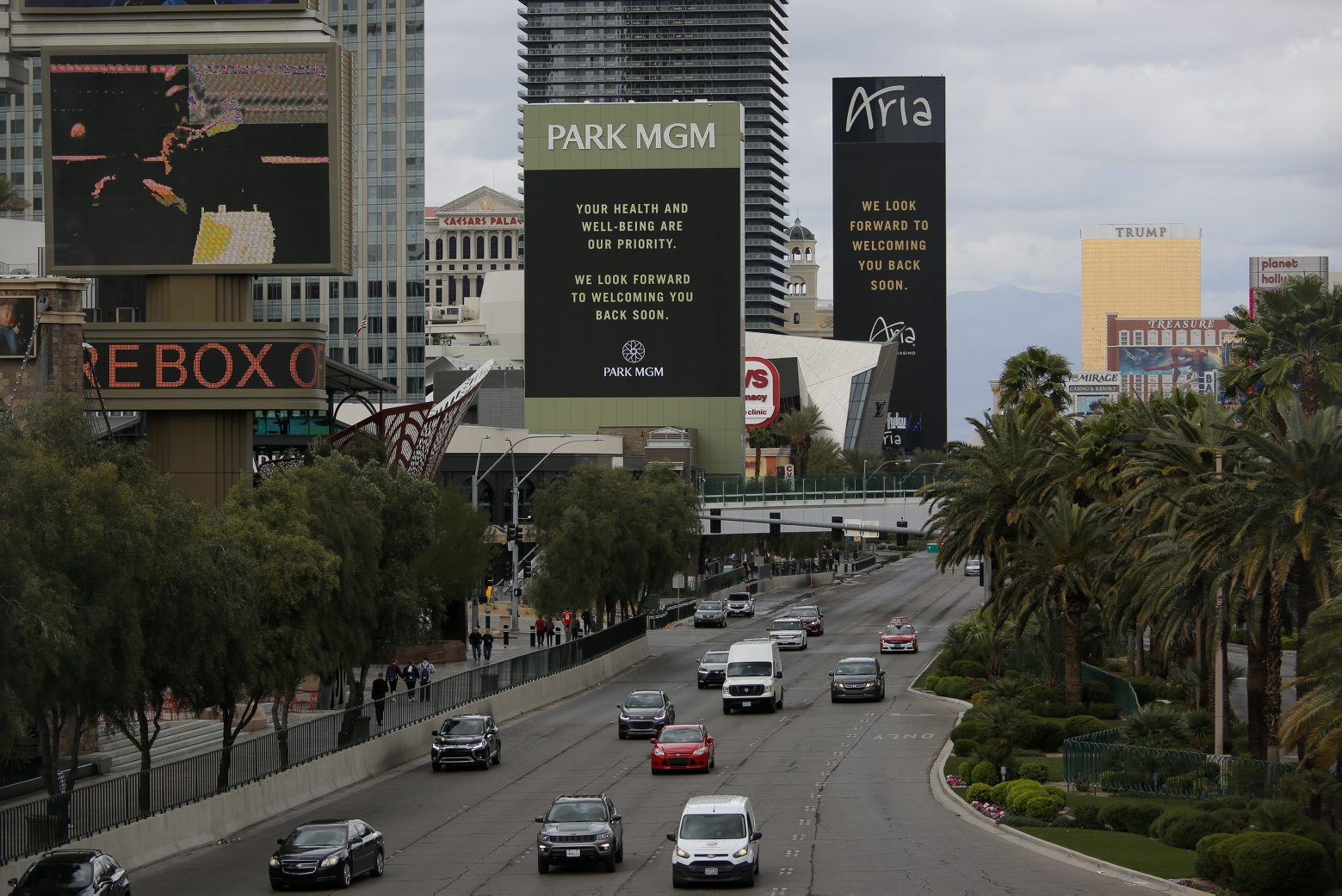 The Park MGM and Aria hotel-casinos flash messages on their closing due to the coronavirus, Monday, March 16, 2020, in Las Vegas. MGM Resorts International and Wynn Resorts will close their Las Vegas properties as of March 17 in light of the coronavirus pandemic. (AP Photo/John Locher) Virus Outbreak Nevada