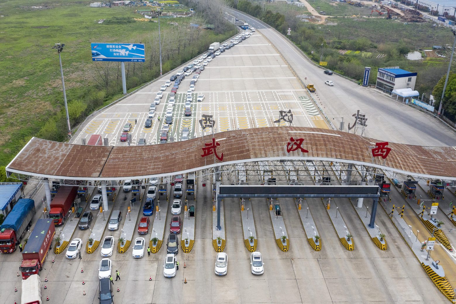 In this March 24, 2020, photo released by Xinhua News Agency, an aerial photo shows vehicles waiting to cross into Wuhan at a highway toll station in Wuhan, in central China's Hubei Province. Hubei has ended a lockdown for most of the province, allowing people who have passed health checks to leave for the first time in two months. The provincial capital of Wuhan, where the virus hit hardest, remains locked down until April 8. (Cai Yang/Xinhua via AP) Virus Outbreak China