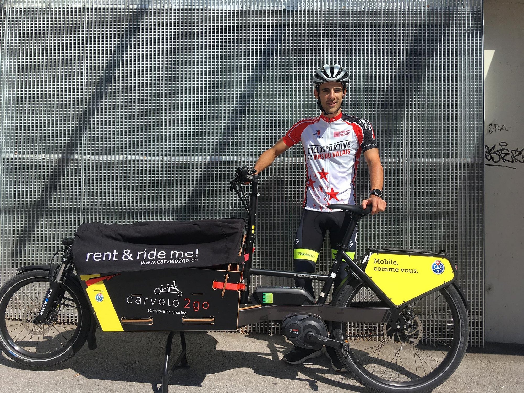 Antoine Debons enfile son t-shirt de la Cyclosportive des vins du Valais quand il effectue ses livraisons. Dès mardi, son vélo sera aussi décoré aux couleurs de l'épreuve.