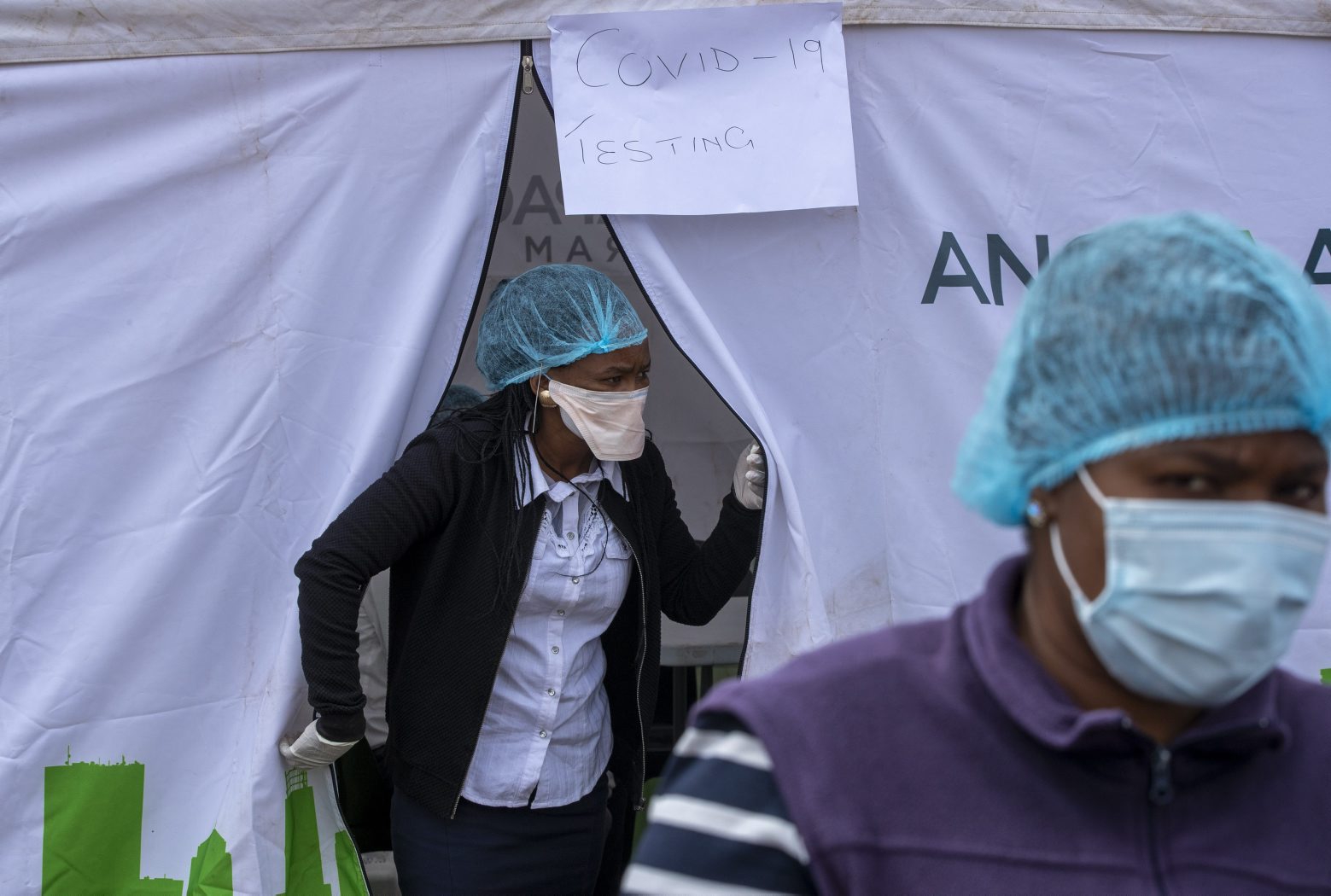 Health workers wearing personal protective gear outside a testing tent, during screening and testing for COVID-19, in Lenasia, south of Johannesburg, South Africa, Wednesday, April 8, 2020.  South Africa and more than half of Africa's 54 countries have imposed lockdowns, curfews, travel bans or other restrictions to try to contain the spread of COVID-19. The new coronavirus causes mild or moderate symptoms for most people, but for some, especially older adults and people with existing health problems, it can cause more severe illness or death. (AP Photo/Themba Hadebe) Virus Outbreak South Africa