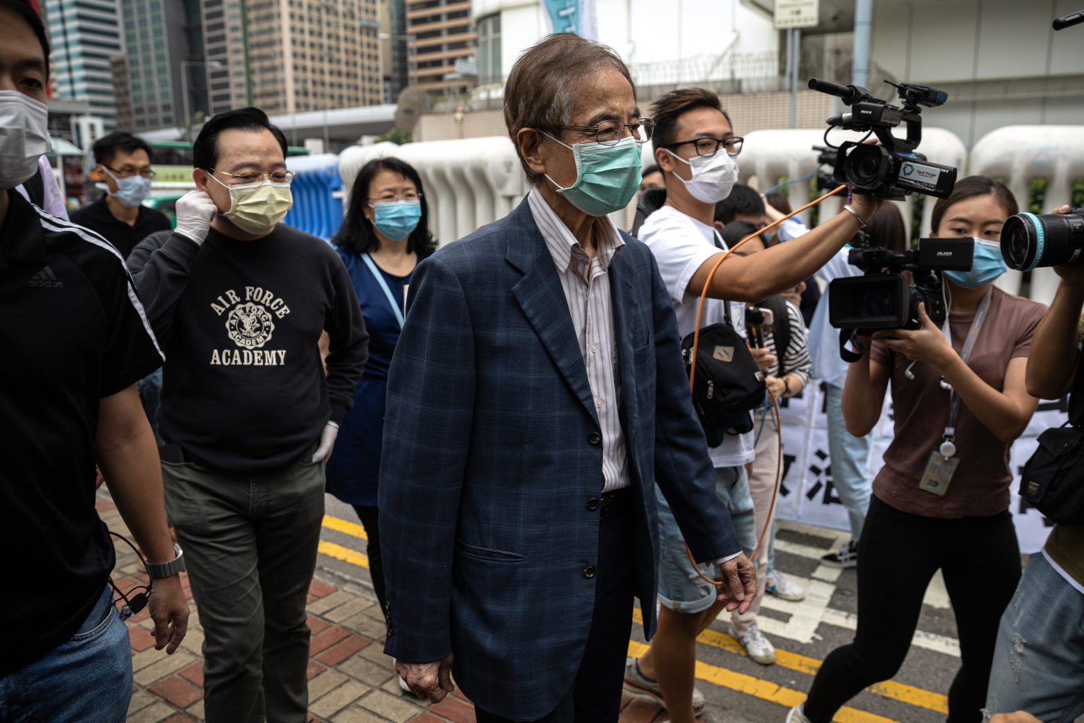 epa08370341 Veteran pro-democracy figure and former lawmaker Martin Lee (C) is chased by journalists after walking out of Central Police Station in Hong Kong, China, 18 April 2020.  Police arrested 14 high-profile pro-democracy figures in connection with several anti-government protests of 2019, including media tycoon Jimmy Lai and veteran pro-democracy figure and former lawmaker Martin Lee.  EPA/JEROME FAVRE CHINA HONG KONG PRO-DEMOCRACY ARRESTS