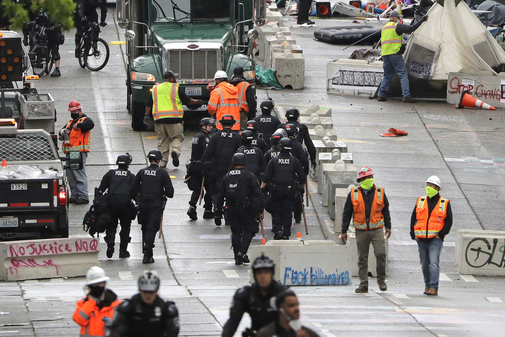 Des policiers en tenue anti-émeute ont investi la rue occupée par un mouvement de manifestants, à Seattle, chef-lieu de l'Etat de Washington, sur la côte Pacifique des Etats-Unis.