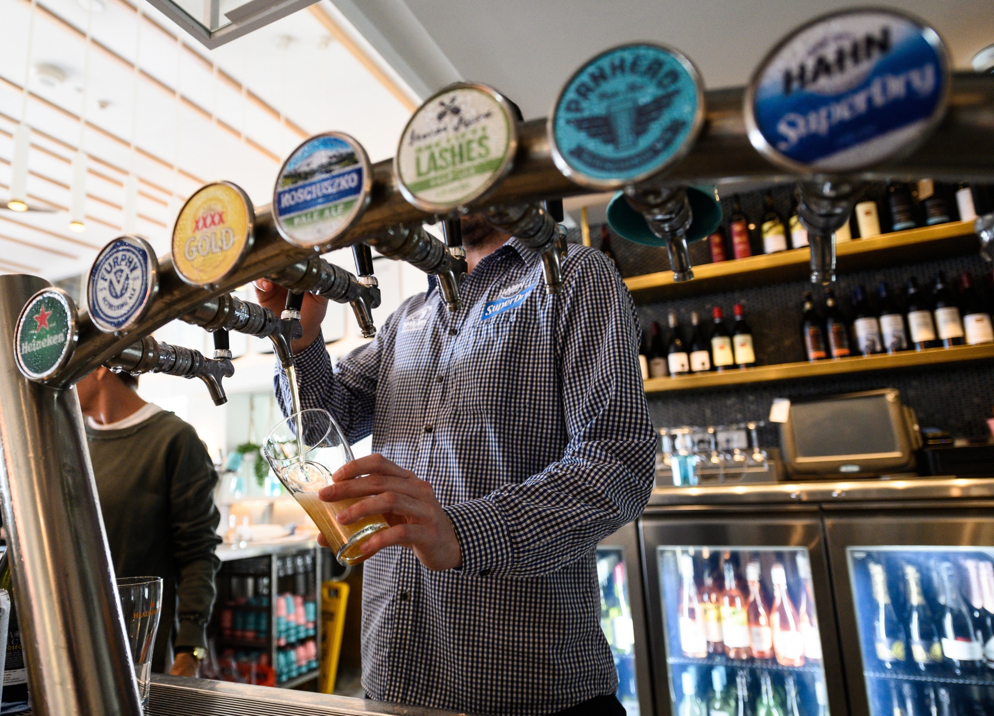 epa08457222 A barman pouring a beer at Bondi Beach, Sydney, Australia, 01 June 2020. Coronavirus restrictions are slowly being eased across Australia with states and territories at different stages on the roadmap to reopen the nation.  EPA/JAMES GOURLEY  AUSTRALIA AND NEW ZEALAND OUT
ArcInfo